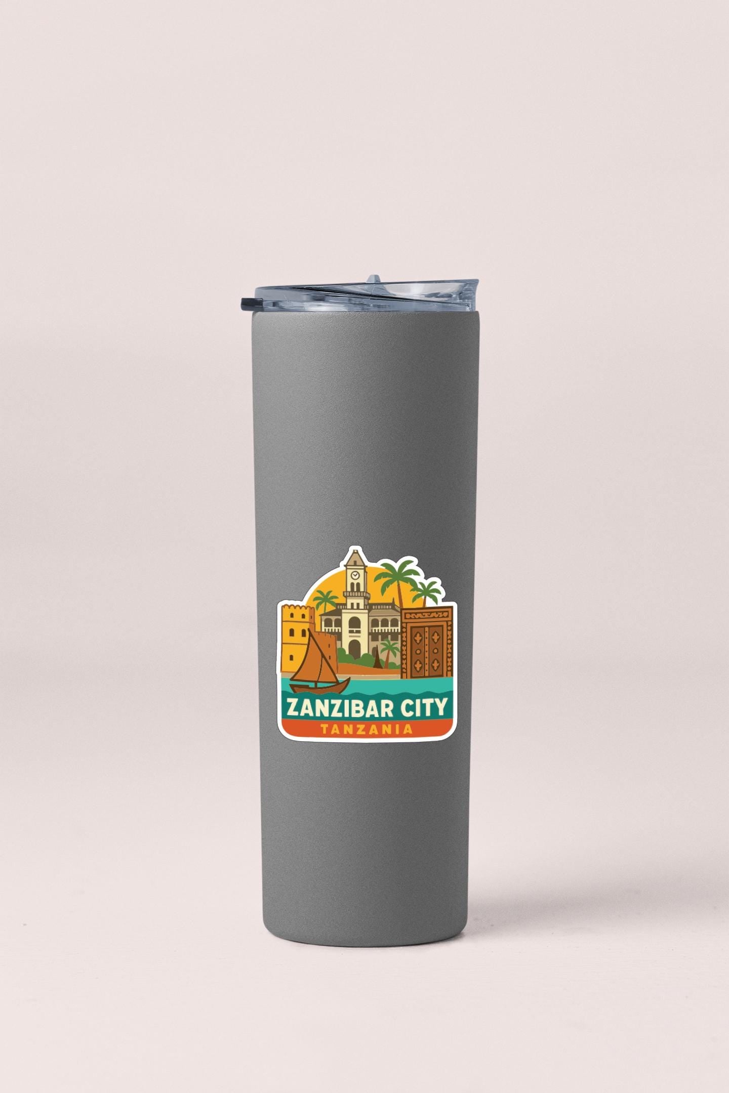 A gray insulated tumbler with a sticker depicting the landmarks of Zanzibar City, Tanzania.