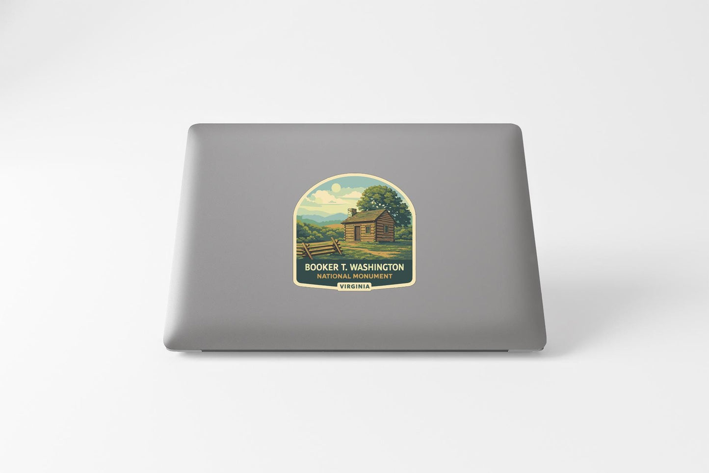 a sticker on a laptop with a vintage-style illustration of a cabin in a rural setting.