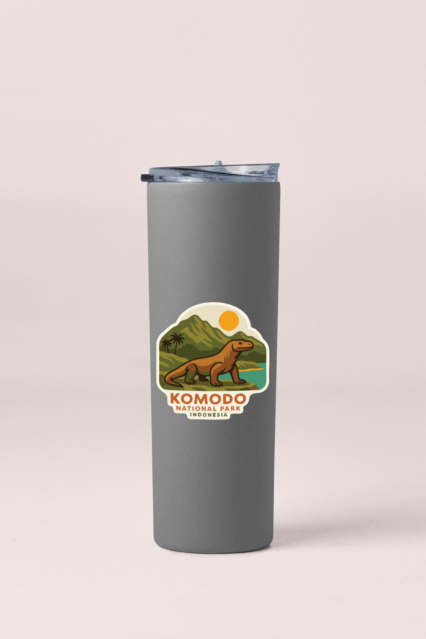 A gray insulated tumbler with a sticker depicting Komodo National Park in Indonesia.