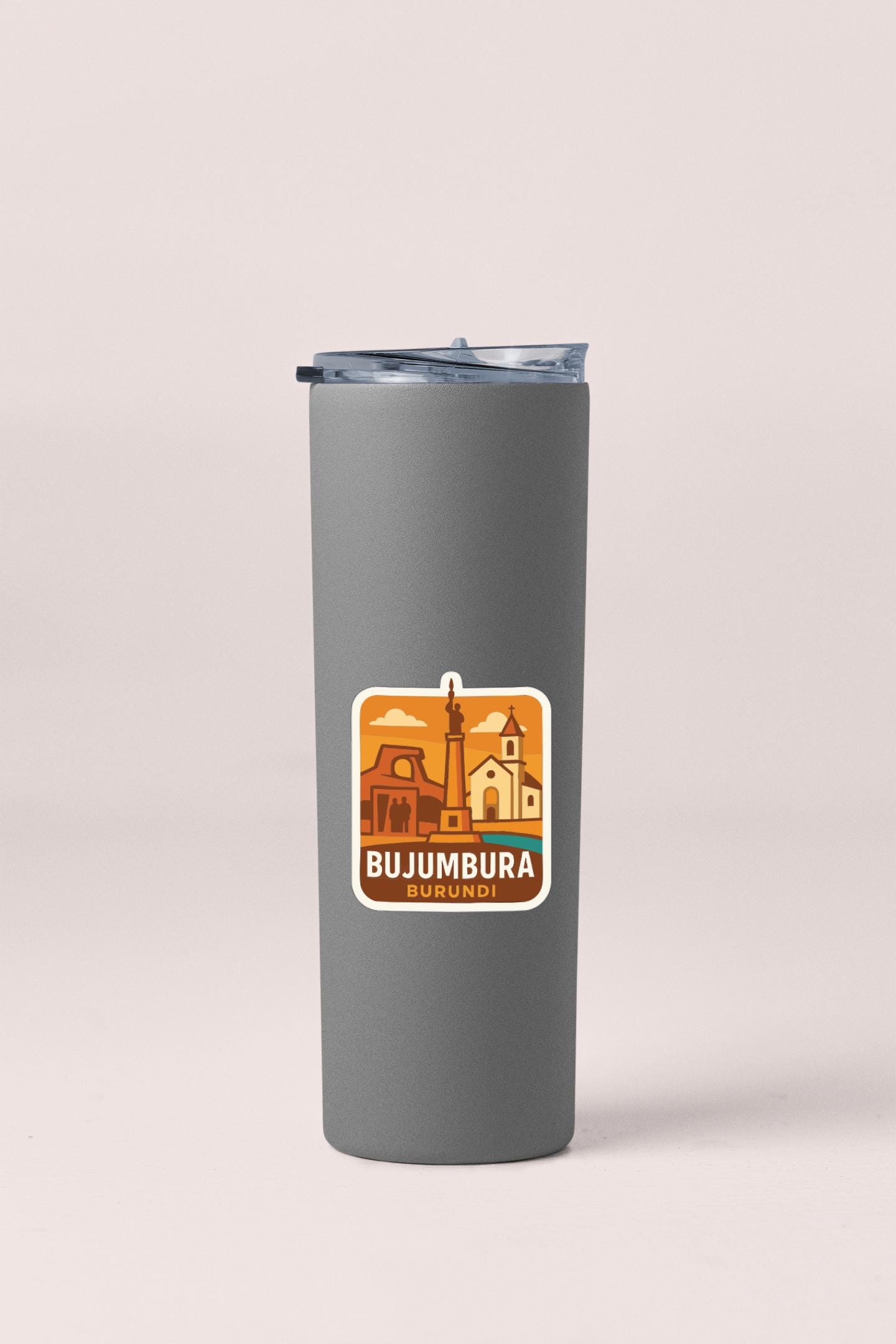 A gray insulated tumbler with a sticker depicting the city of Bujumbura, Burundi.