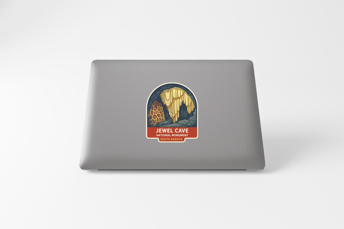 a sticker on the back of a laptop, depicting a cave with a yellow and blue design.