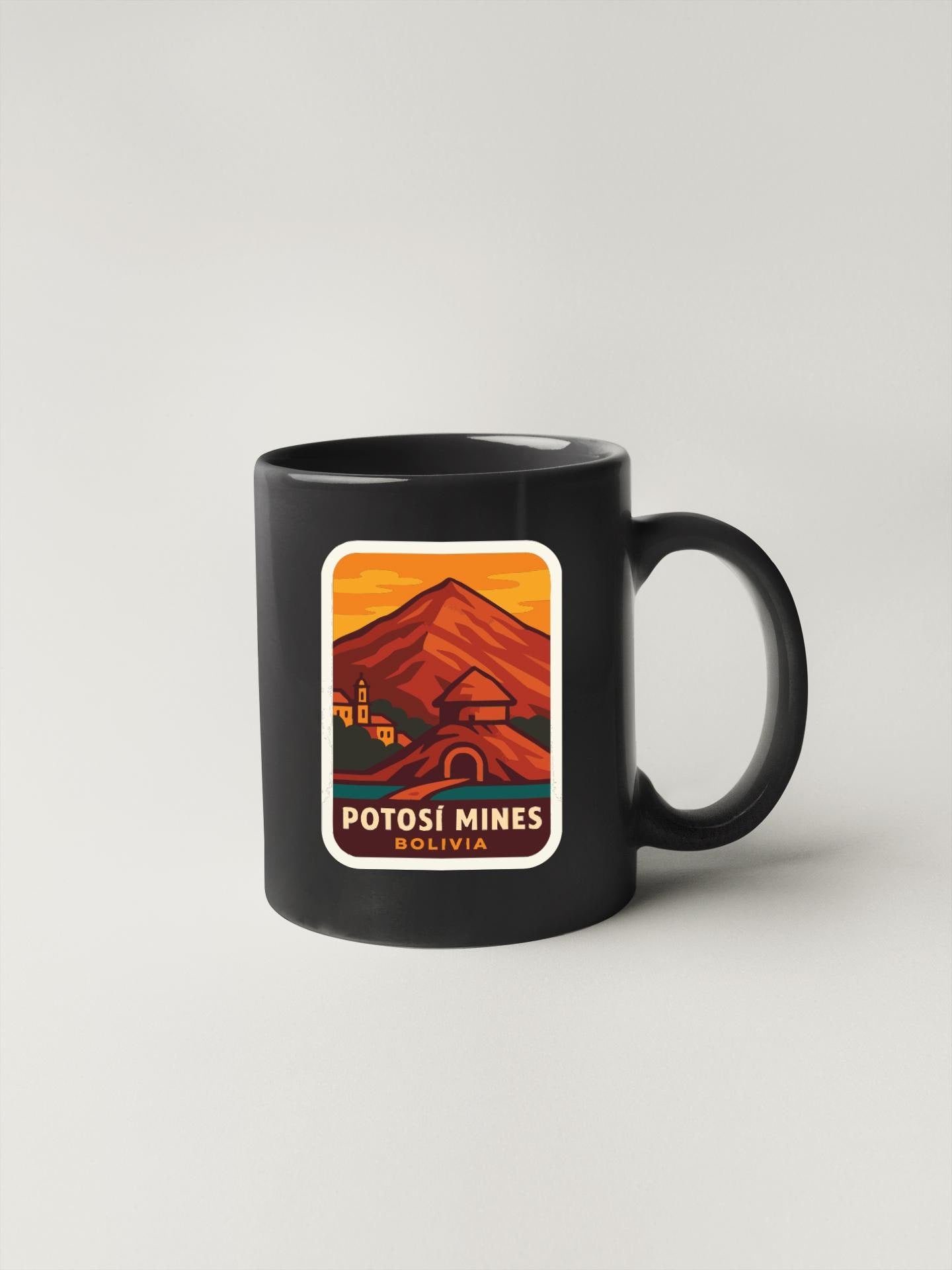 A black coffee mug with a graphic design depicting a mountain landscape and a small village.