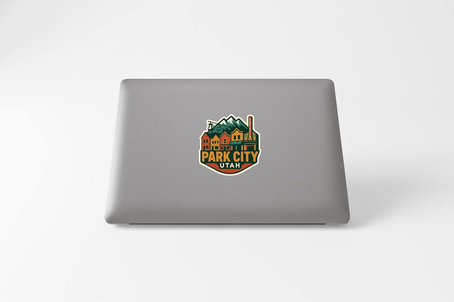 A sticker on the back of a laptop, featuring a colorful illustration of a mountain range and the text "Park City, Utah".
