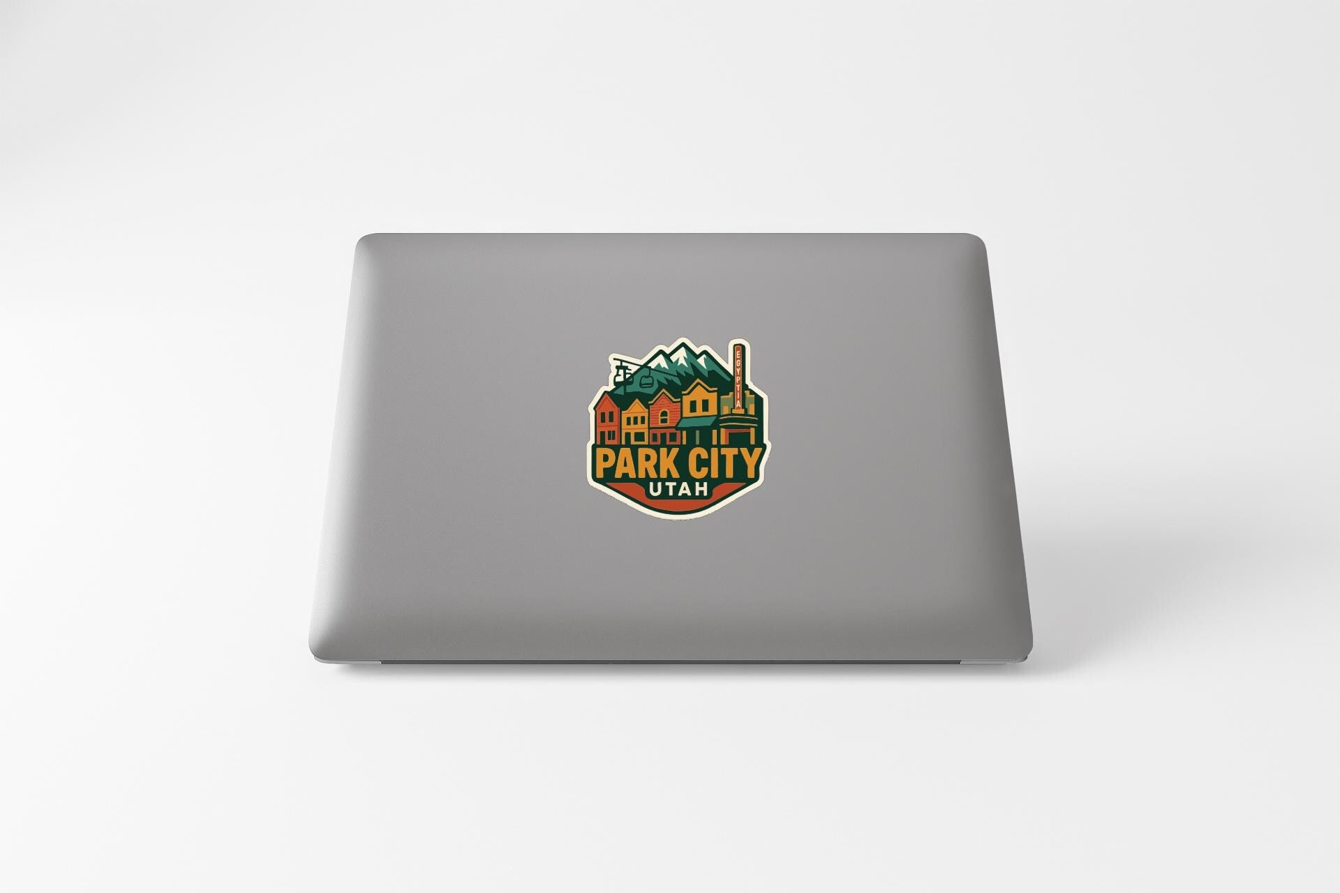 A sticker on the back of a laptop, featuring a colorful illustration of a mountain range and the text "Park City, Utah".