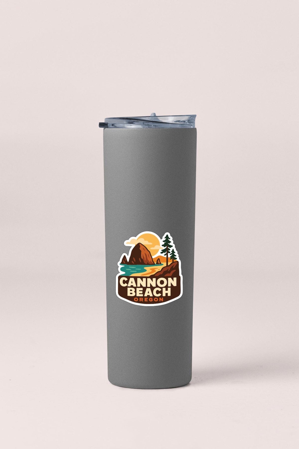 A gray insulated tumbler with a sticker depicting a scenic landscape, including mountains, trees, and a sunset.