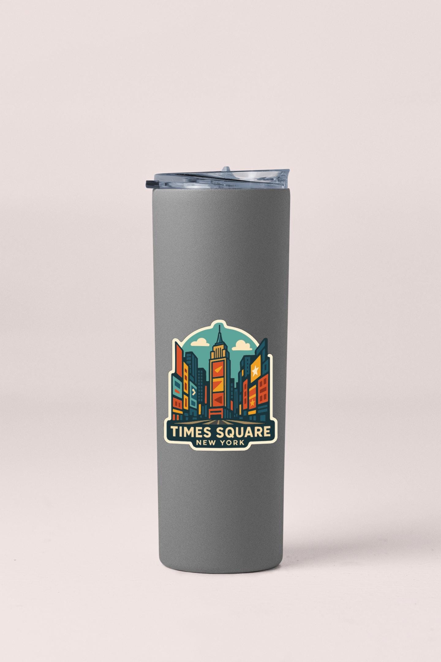 A gray insulated tumbler with a printed design of Times Square in New York City on it.