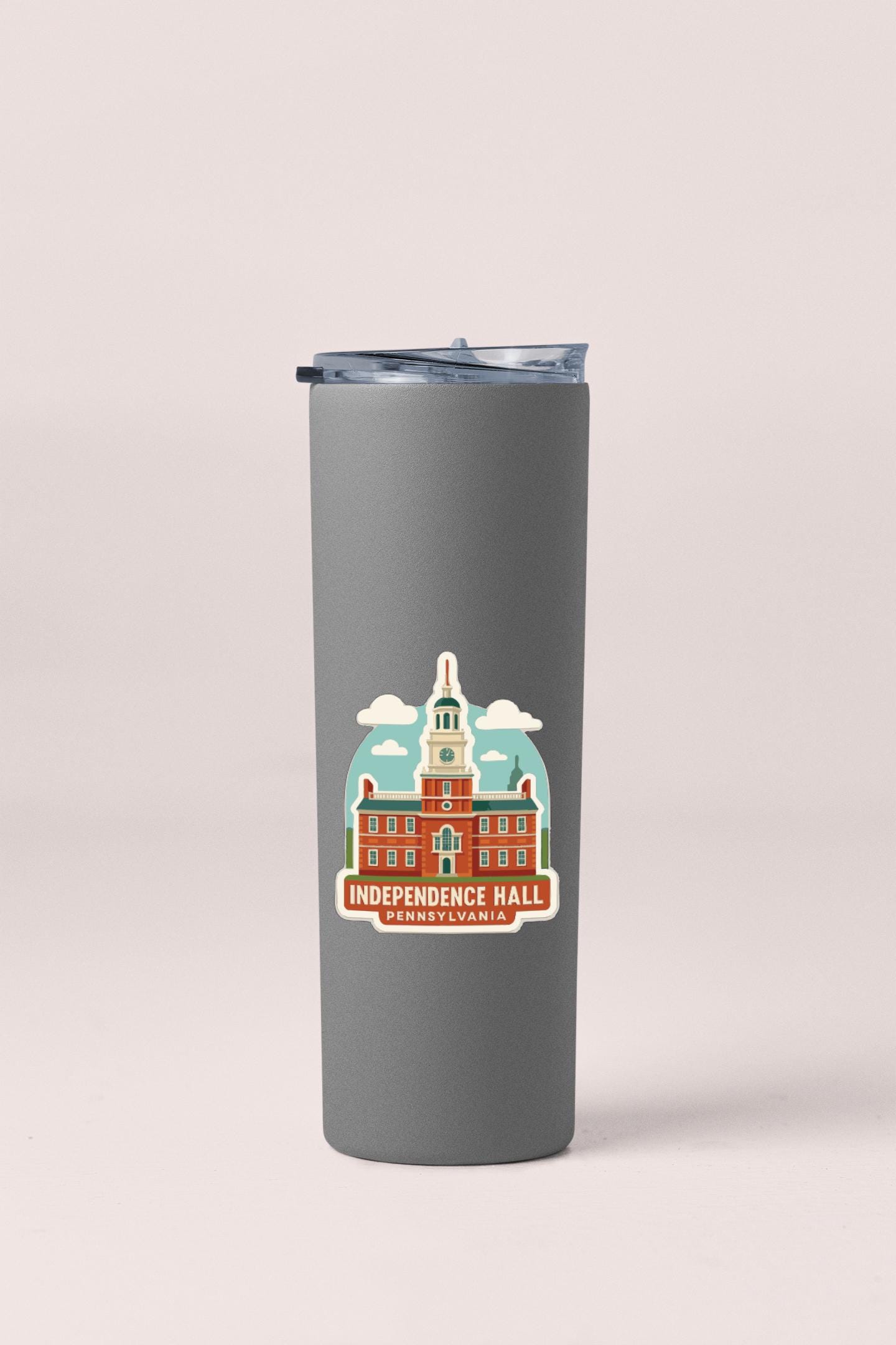 A gray insulated tumbler with a sticker depicting Independence Hall in Philadelphia, Pennsylvania.