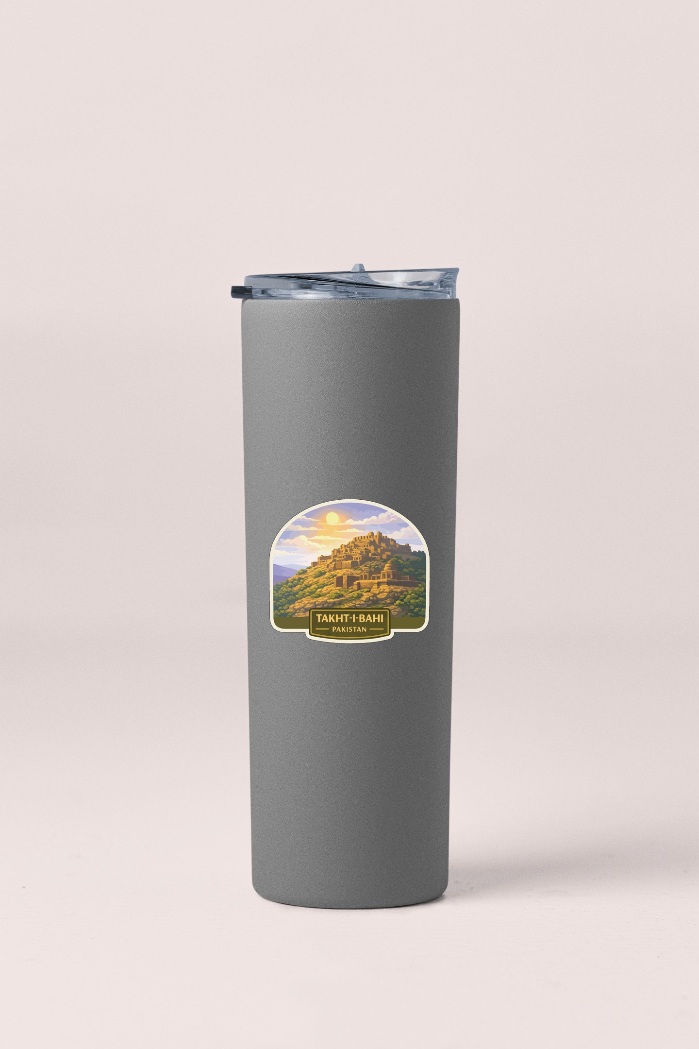 A gray insulated tumbler with a label that features a scenic mountain landscape.
