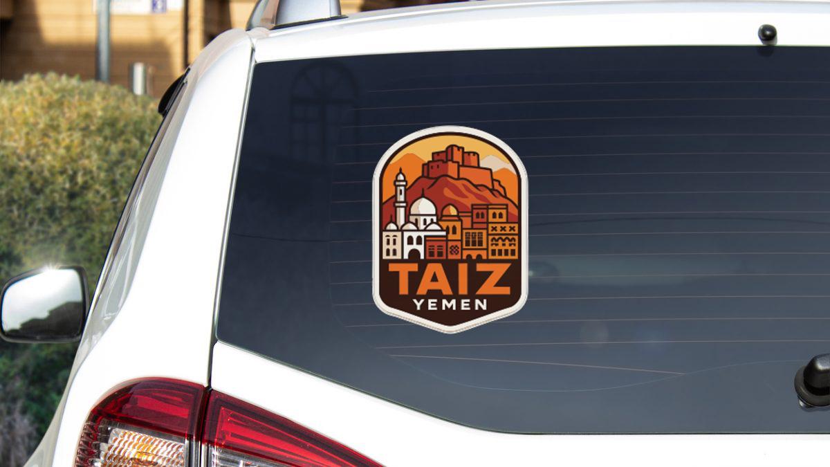 a sticker on the rear window of a white car, depicting a cityscape with a mountain in the background.