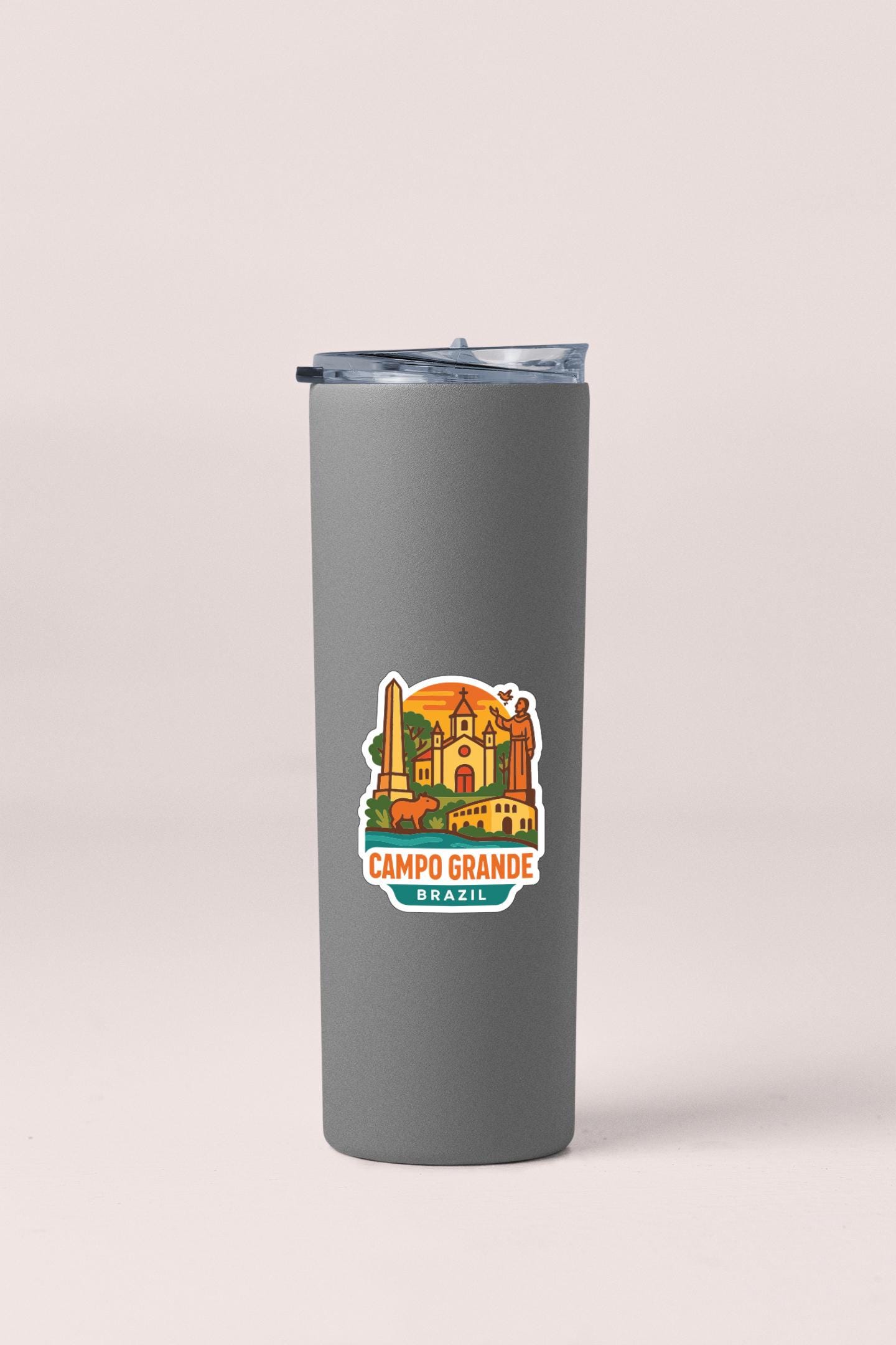 A gray tumbler with a sticker depicting the city of Campo Grande, Brazil.