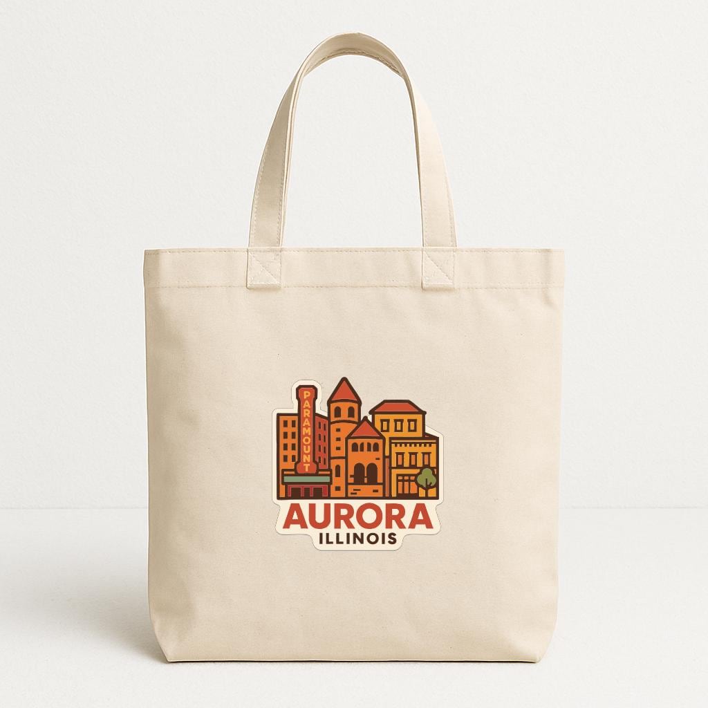 A beige tote bag with a printed design of a city skyline and the text "AURORA ILLINOIS" printed on it.