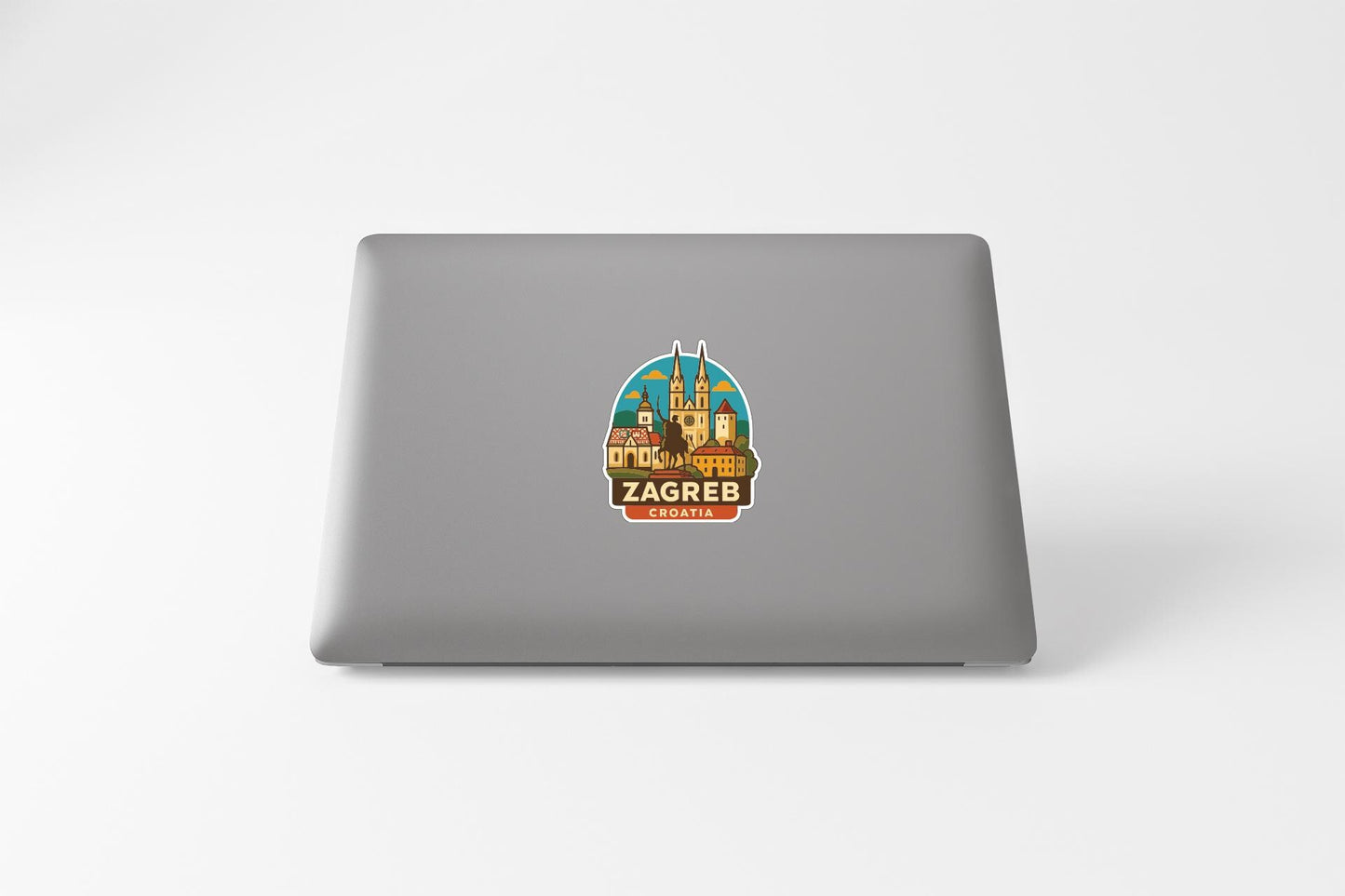 A sticker on the back of a laptop, depicting a cityscape with a castle-like structure.