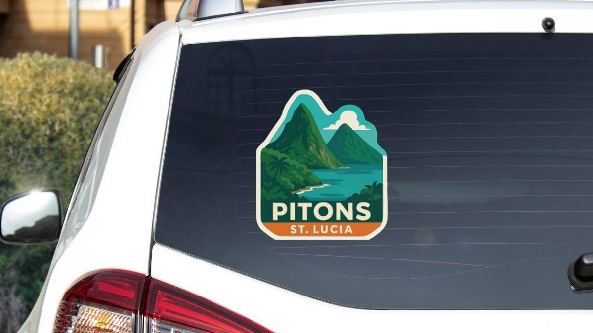 a sticker on the rear window of a white car, depicting a mountain landscape with a lake and a mountain range.
