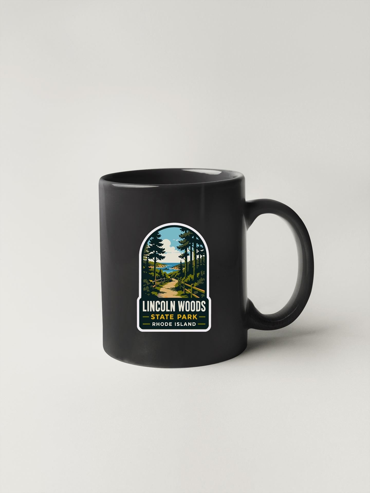 A black coffee mug with a label that says "Lincoln Woods State Park, Rhode Island".