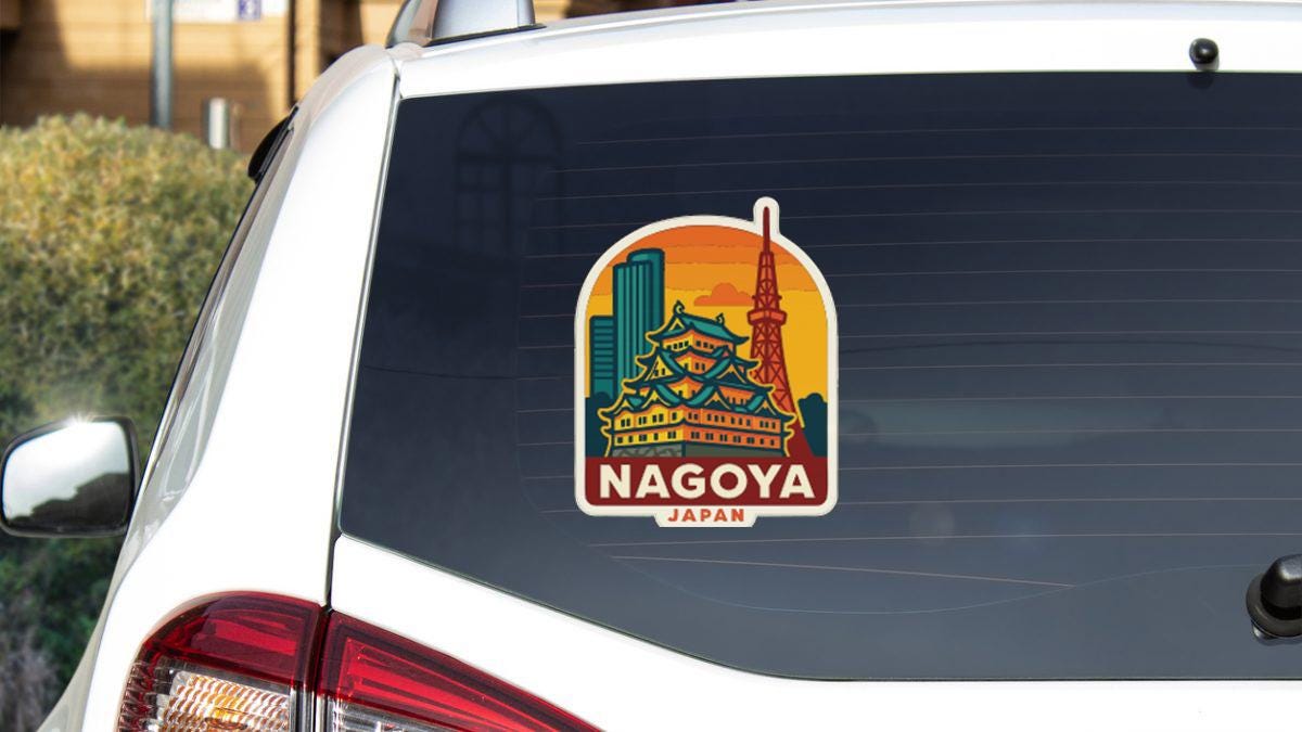 A sticker on the rear window of a car that features the Nagoya skyline and the Tokyo Tower, indicating that the car is traveling to Nagoya, Japan.