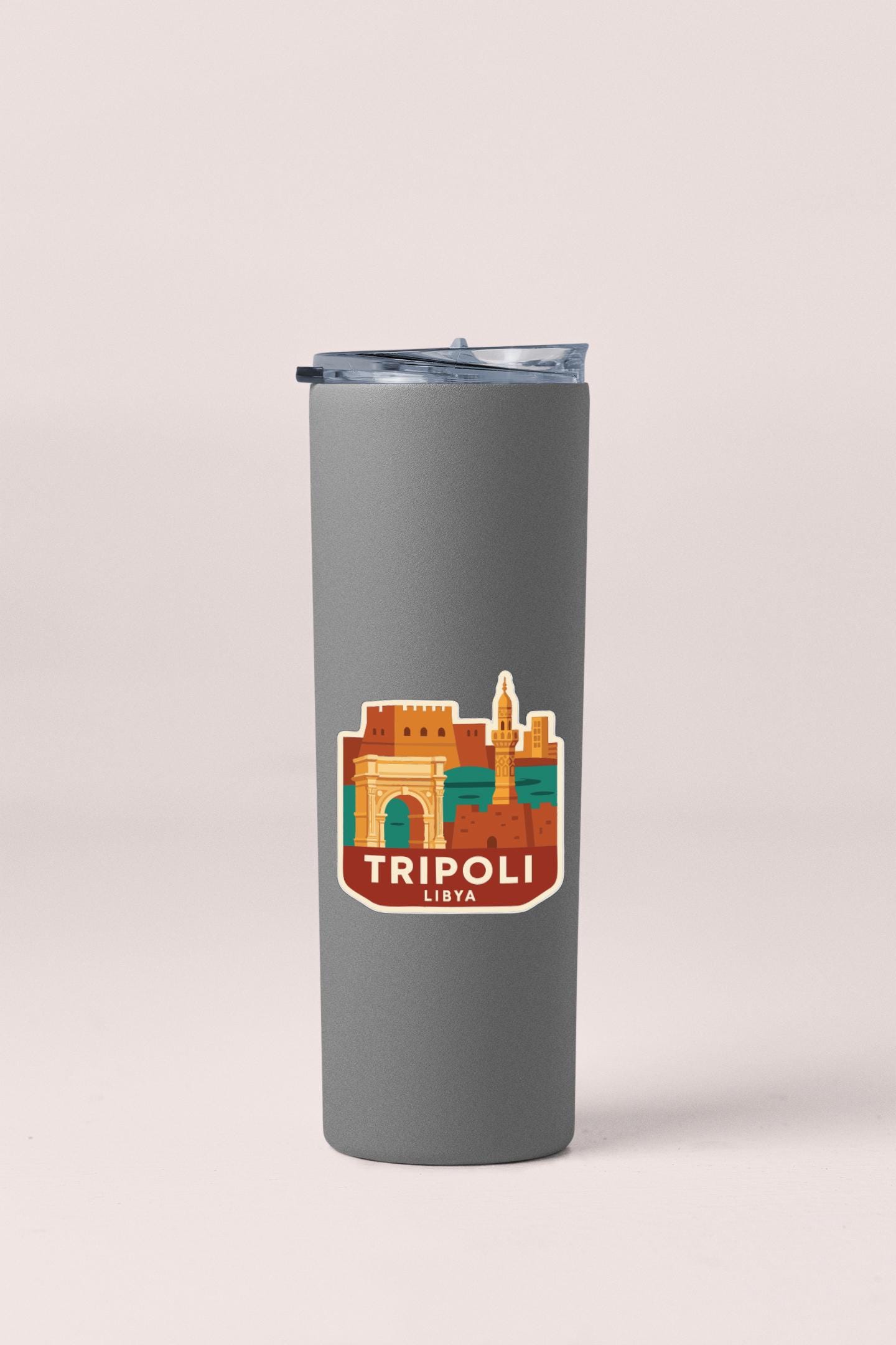 A gray insulated tumbler with a sticker depicting the city of Tripoli, Libya.
