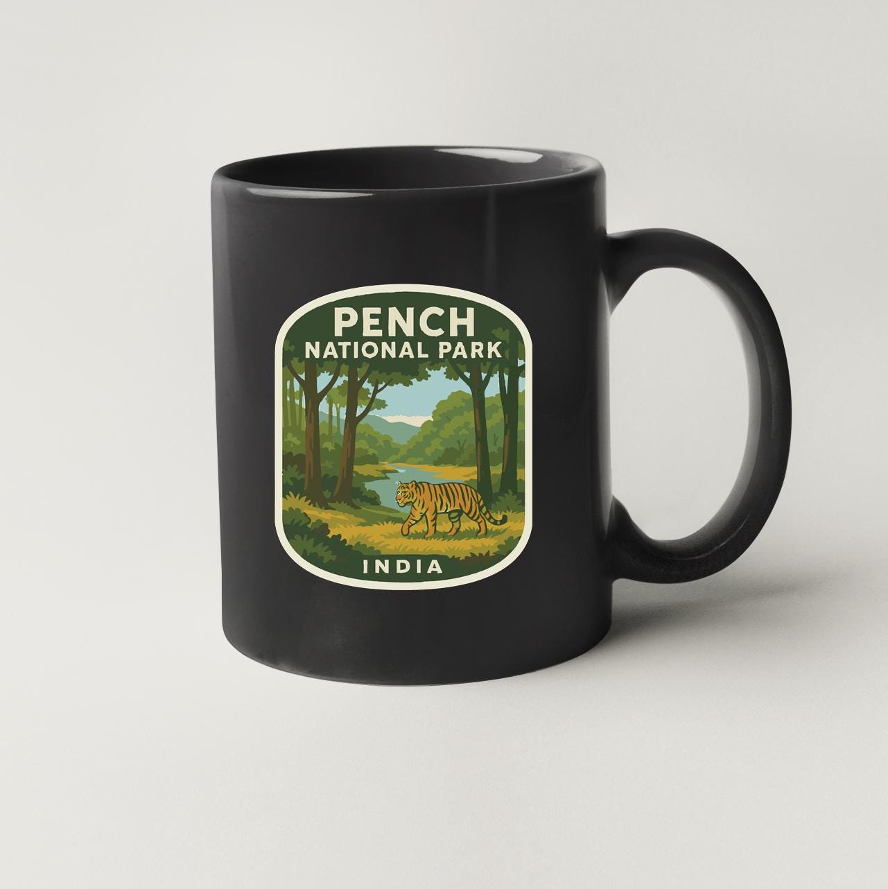 A black coffee mug with a label that says "PENCH NATIONAL PARK INDIA".