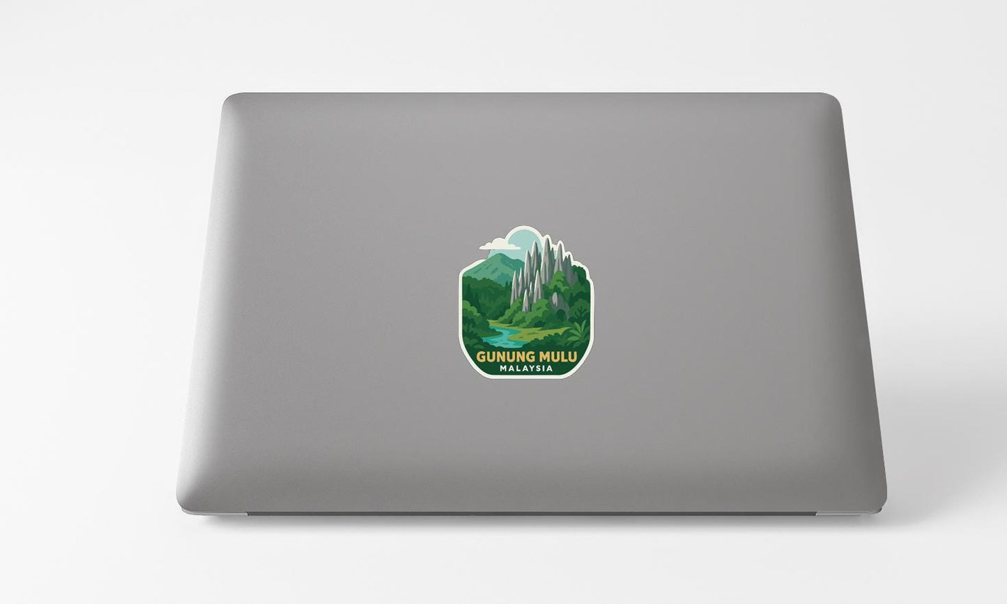 A sticker on the back of a laptop displaying a scenic landscape with mountains and a river.
