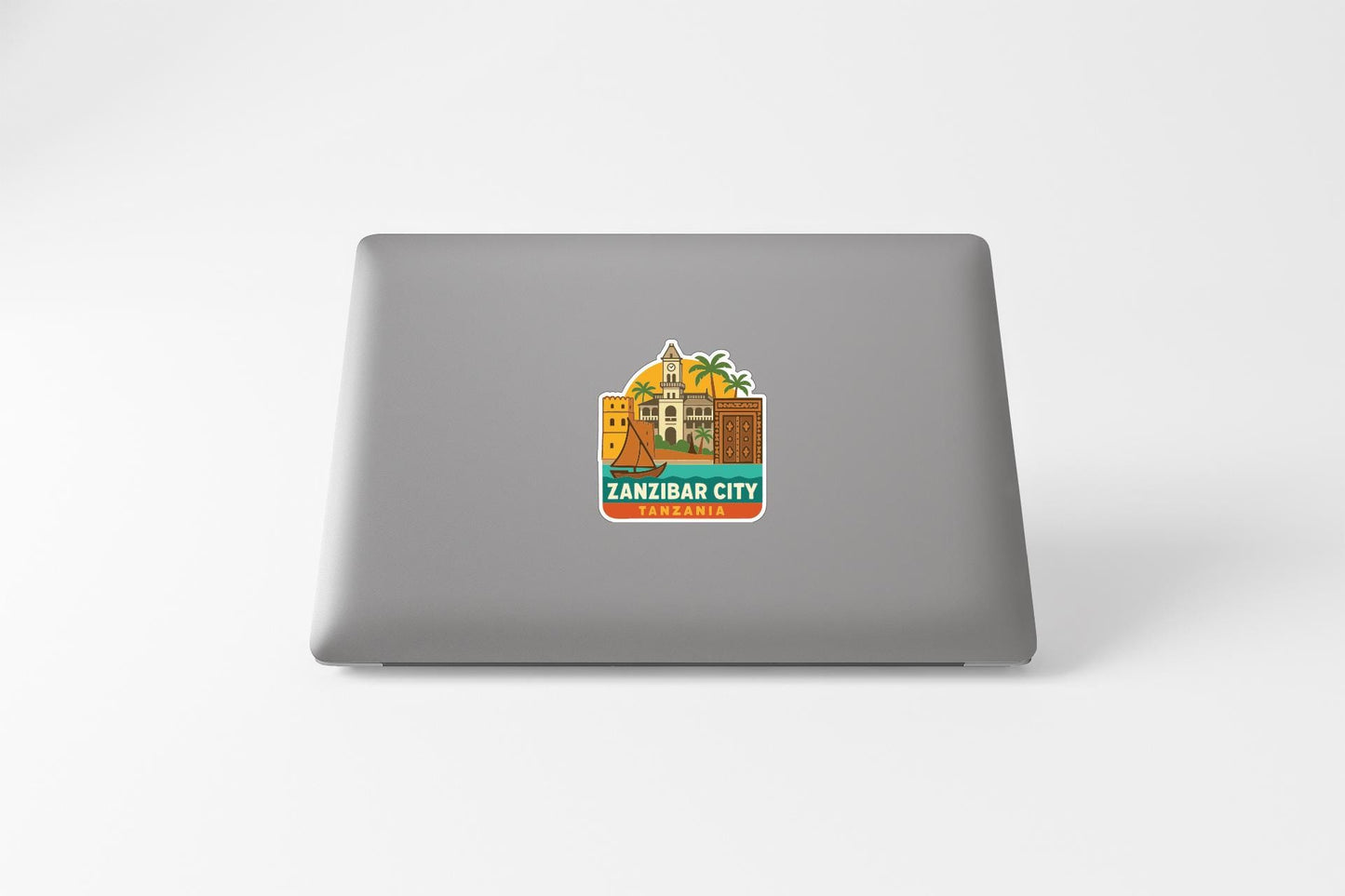 a sticker or decal on the back of a laptop, depicting a tropical city with palm trees and buildings.