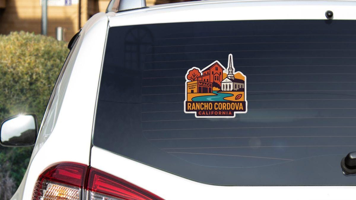 A sticker on the rear window of a white vehicle, depicting a scenic view of Rancho Cordova, California.
