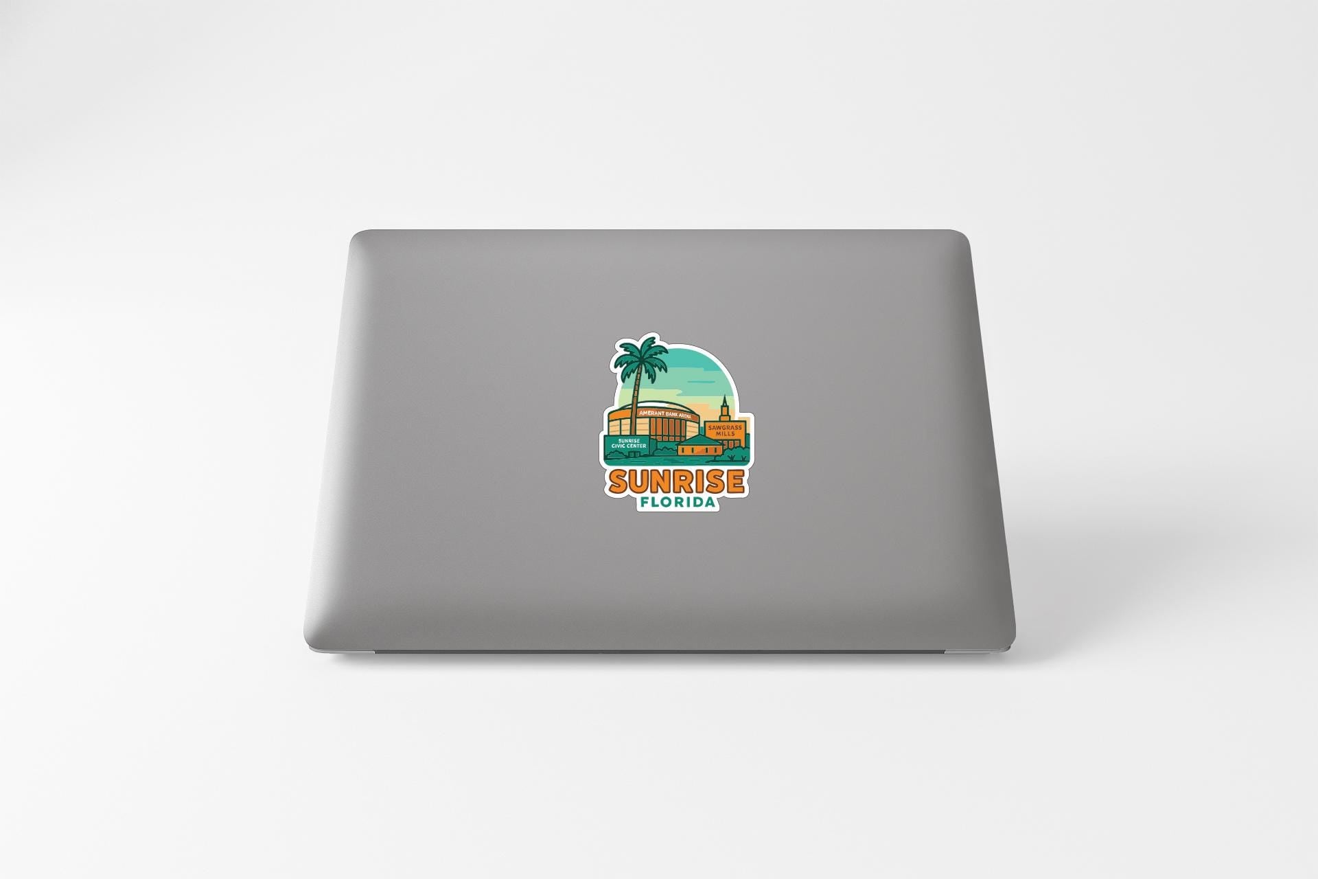 A sticker on the back of a laptop that features a palm tree and a building, along with the text "SUNRISE FLORIDA".
