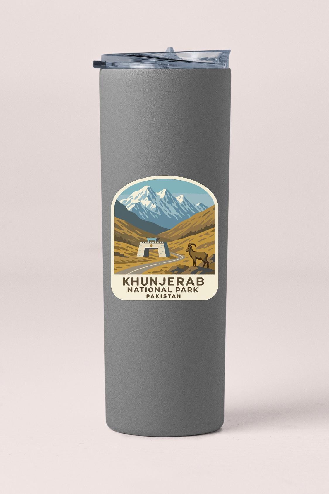 A gray cylindrical container with a label that features an illustration of a mountain landscape and a small building, along with the text "KHUNJERAB NATIONAL PARK PAKISTAN".
