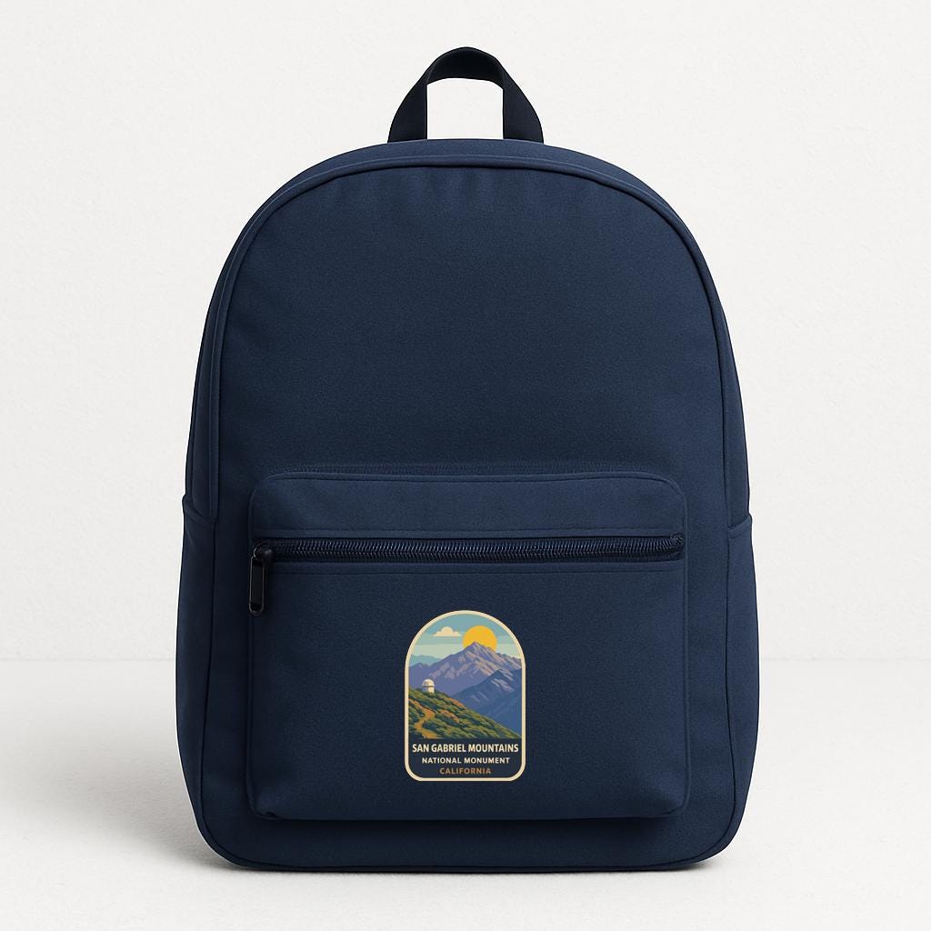 A navy blue backpack with a graphic of a mountain range and the text "SAN GABRIEL MOUNTAINS SAN GABRIEL MOUNTAINS" printed on it.
