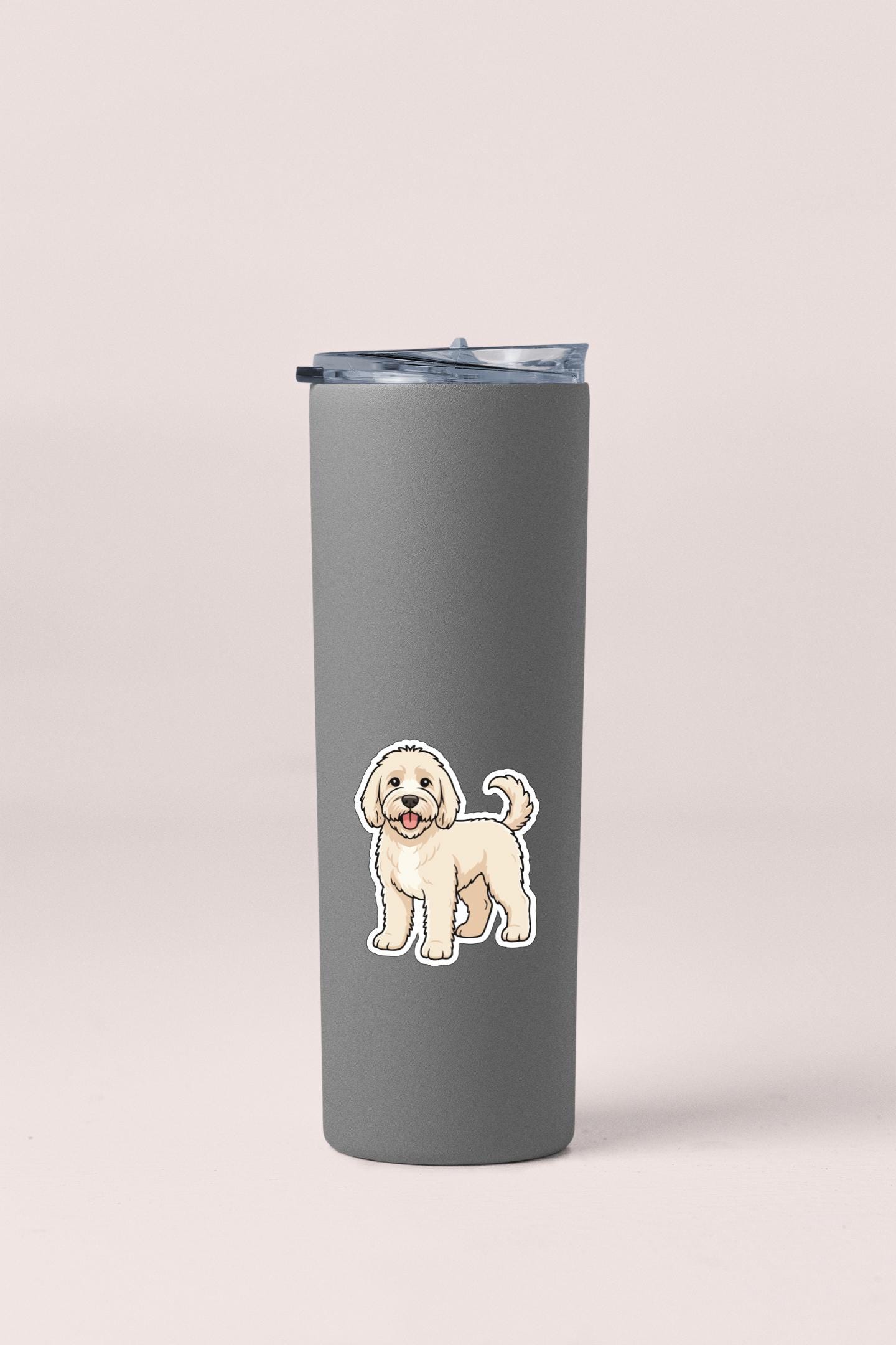 A gray insulated tumbler with a sticker of a cartoon dog on it.