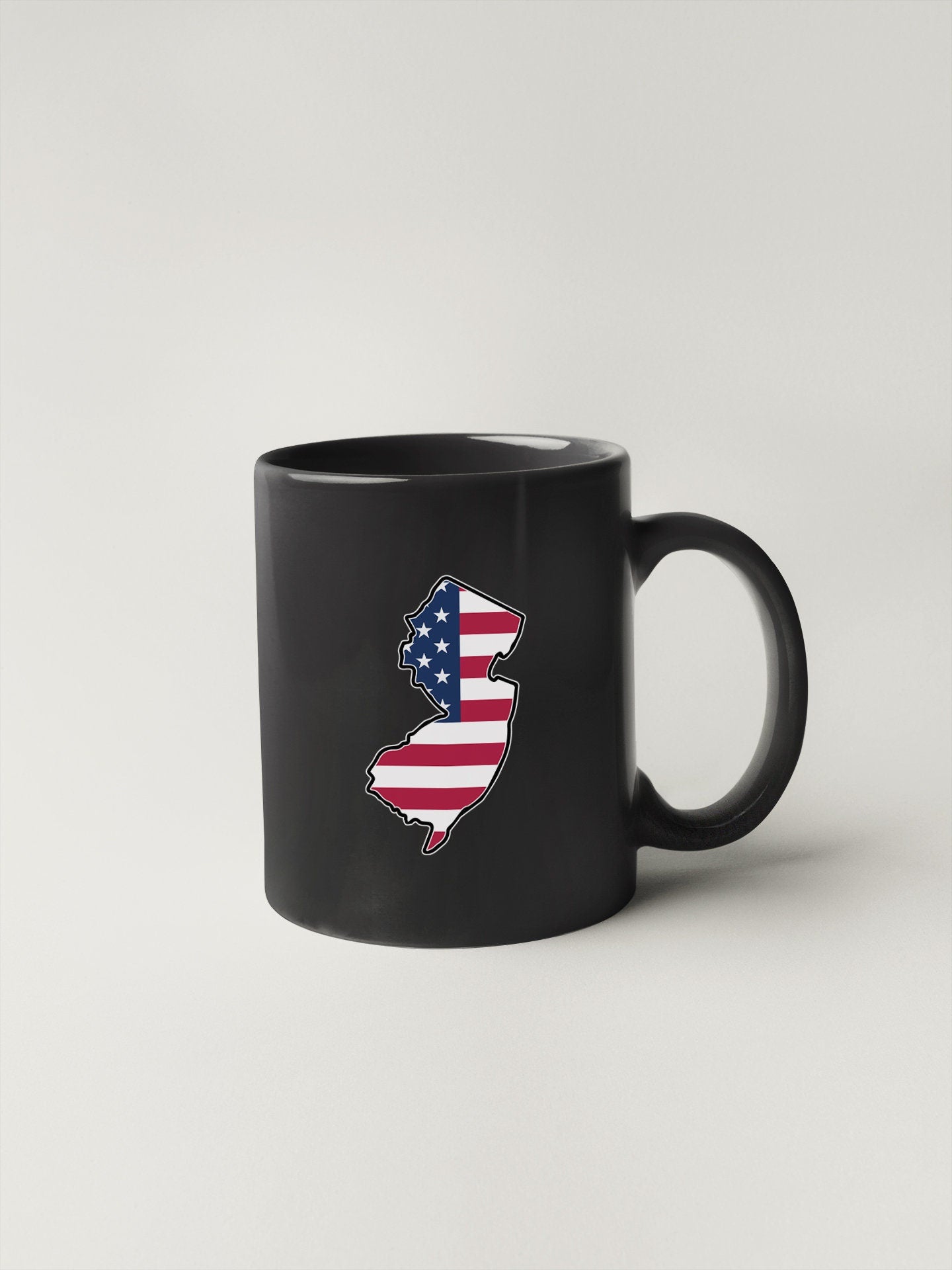 a black coffee mug with an american flag on it