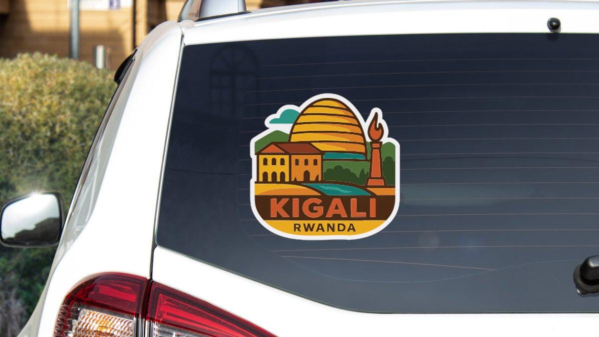 a sticker on the rear window of a car that displays the name "Kigali" and the country of Rwanda.