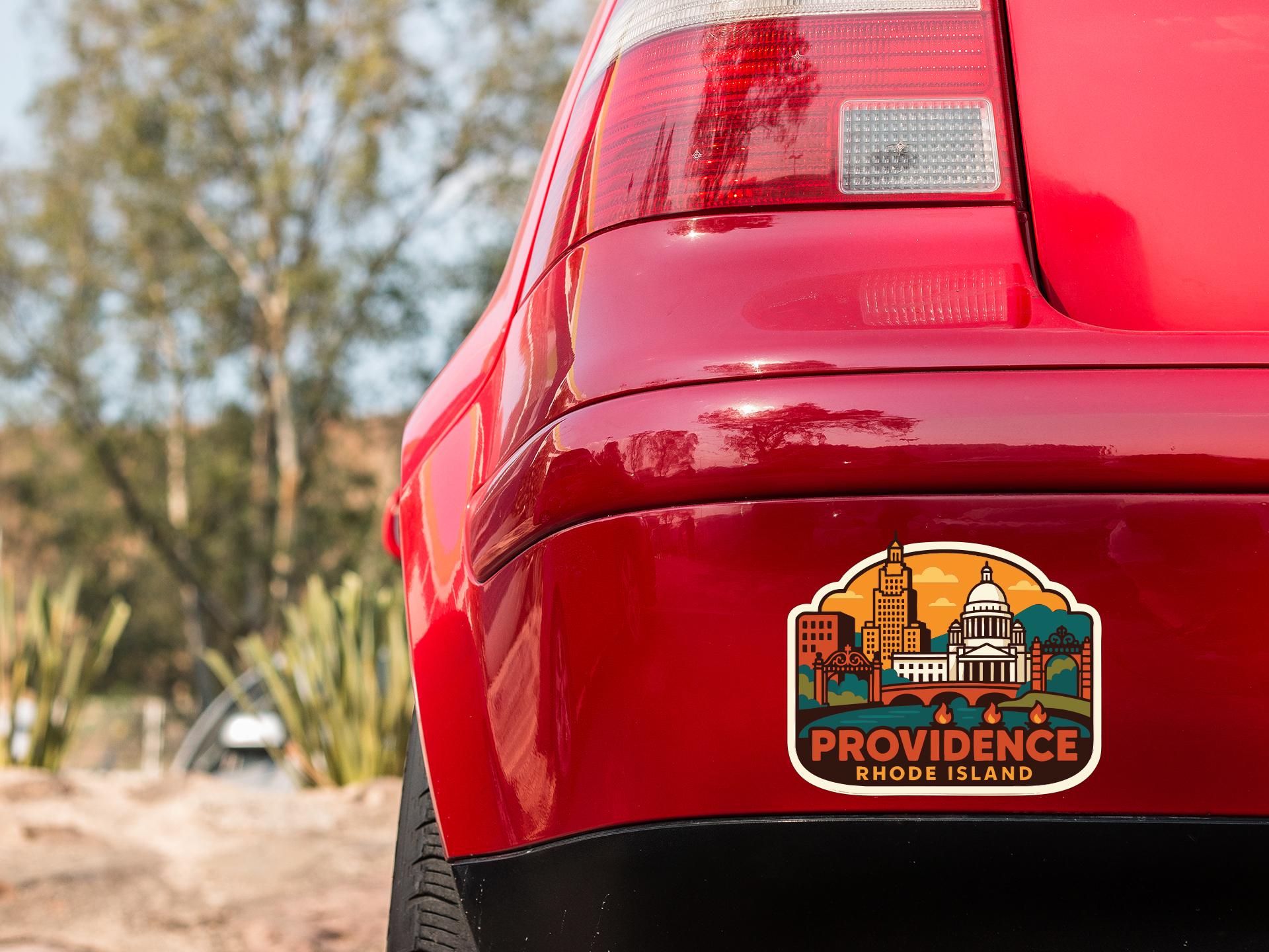 the rear end of a red car with a sticker on the trunk that features an illustration of Providence, Rhode Island.