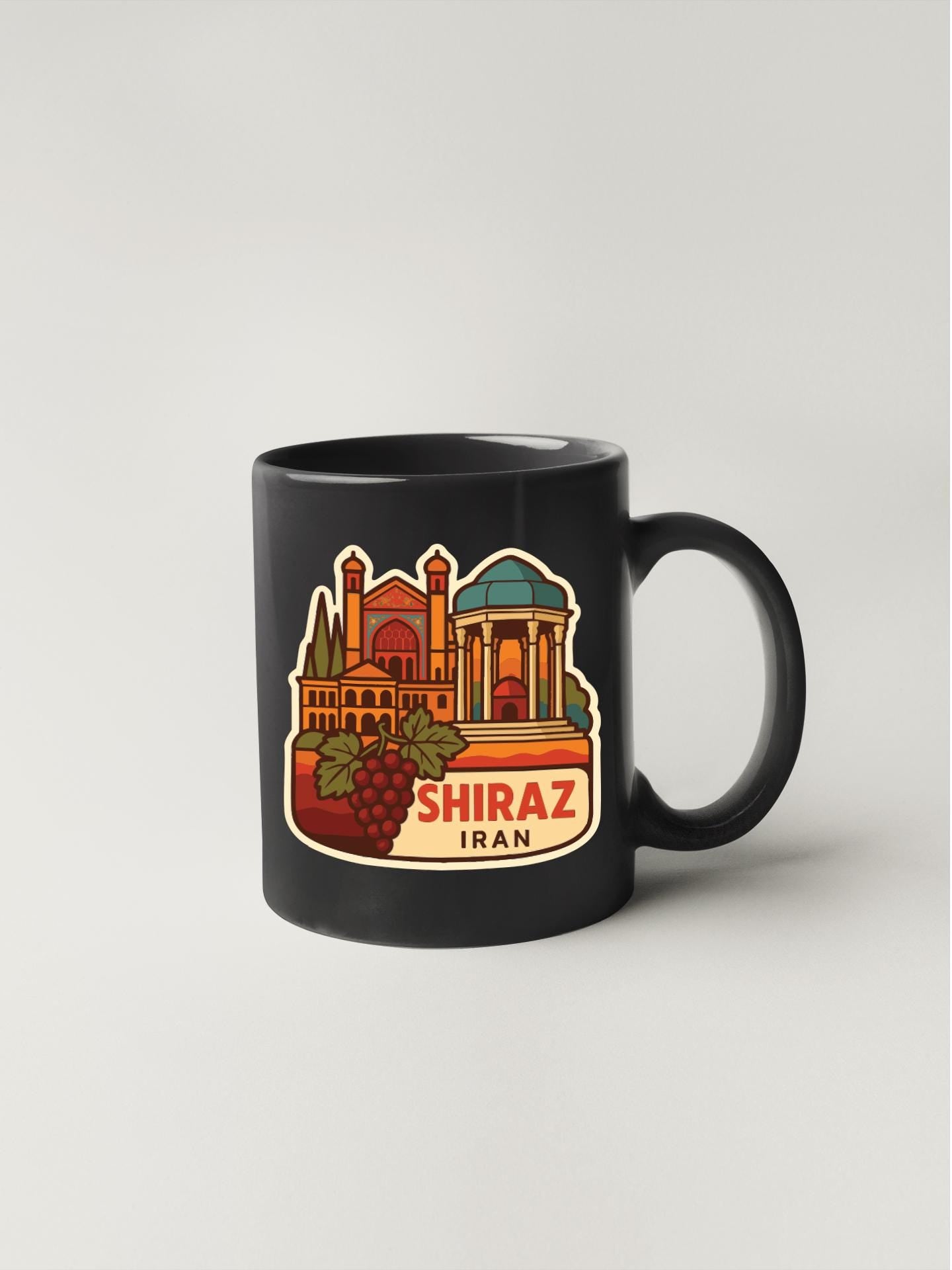 A black coffee mug with a colorful illustration of a cityscape and a grape cluster, along with the text "SHIRAZ IRAN".