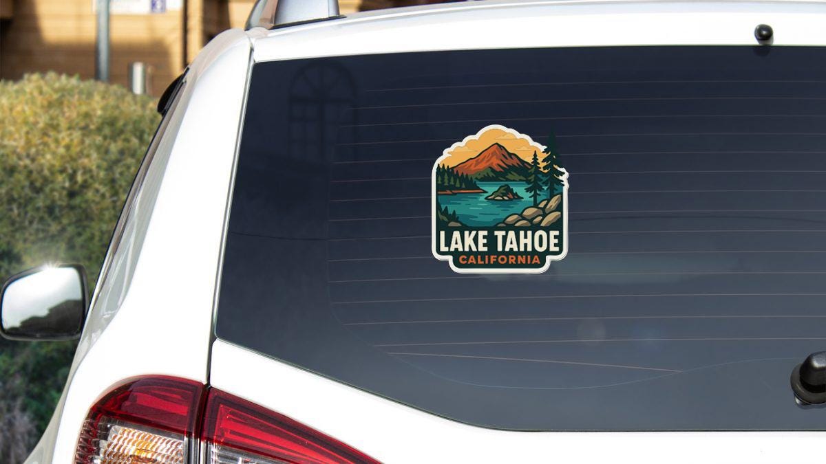 A sticker on the rear window of a white car that says "Lake Tahoe, California".