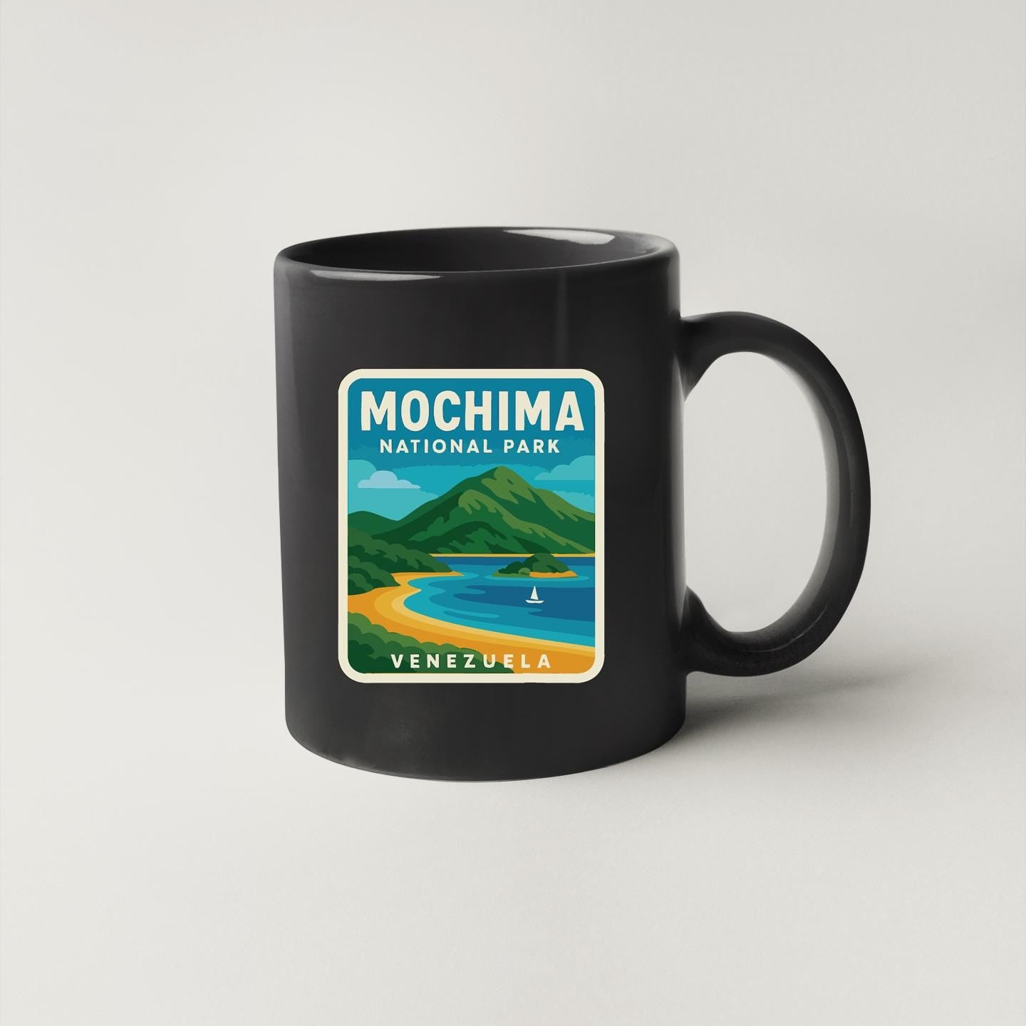 A black coffee mug with a graphic design depicting the Mochima National Park in Venezuela.