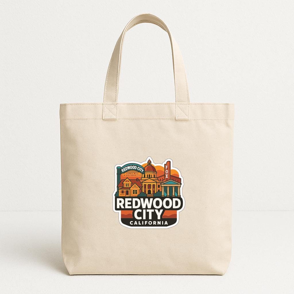 A beige tote bag with a printed design of a cityscape and the text "REDWOOD CITY CALIFORNIA" printed on it.