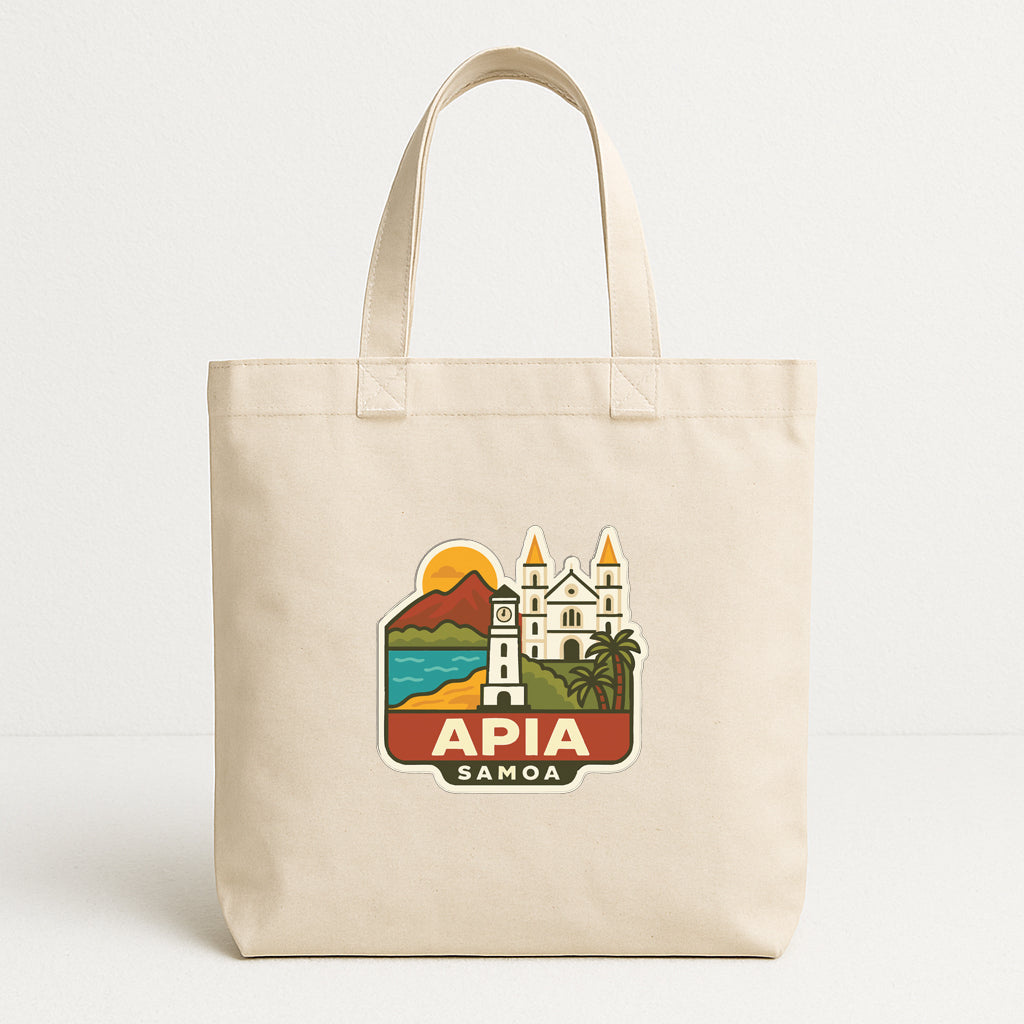 A beige tote bag with a graphic design featuring a lighthouse, mountains, and a building, along with the text "APIA SAMOA".