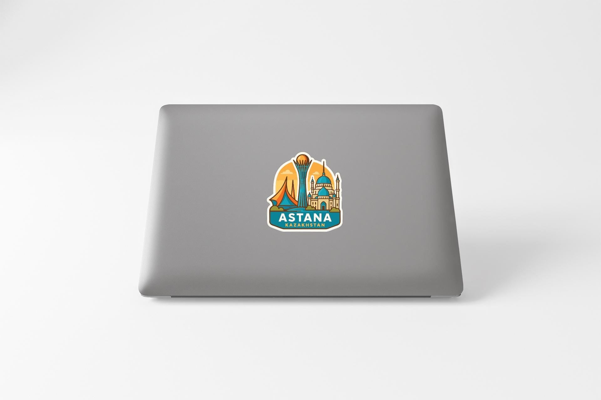 a sticker with a cityscape and the word "ASTANA" on the back of a laptop.