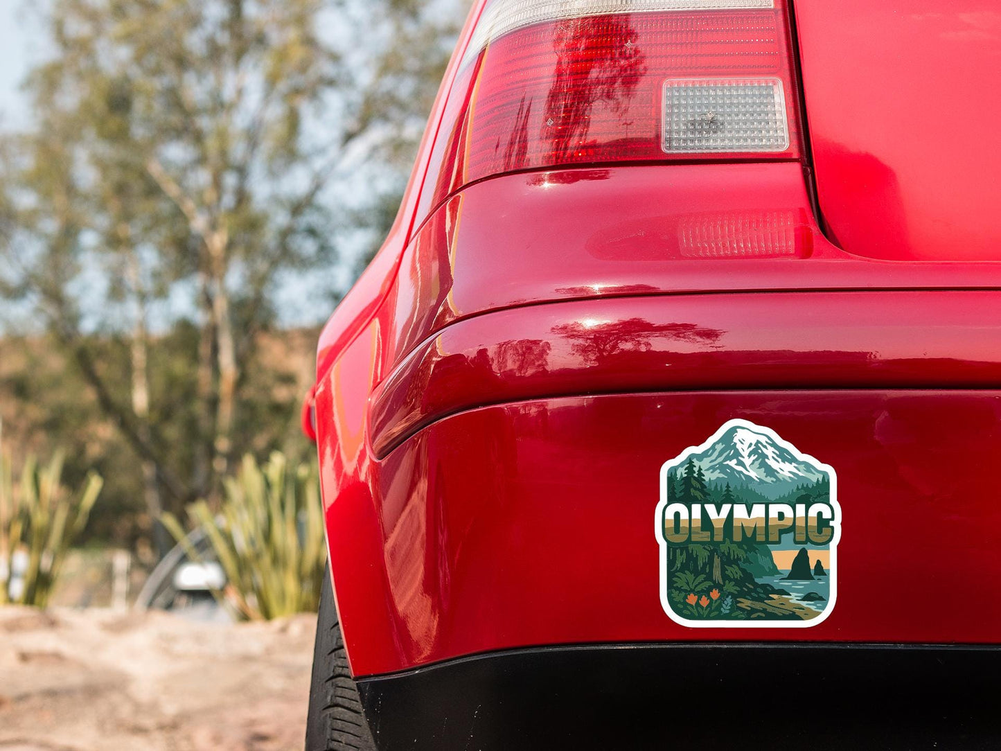 the rear end of a red car with a sticker on the bumper that says "Olympic".