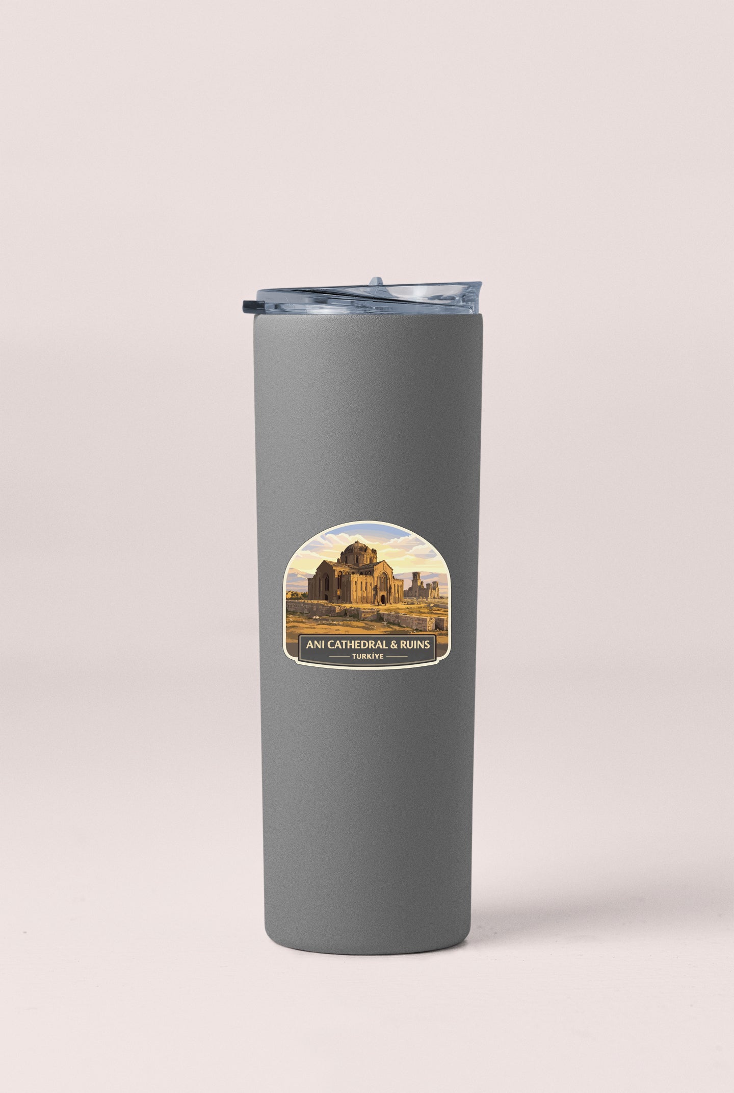 A gray cylindrical thermos with a label featuring an image of a cathedral and ruins.