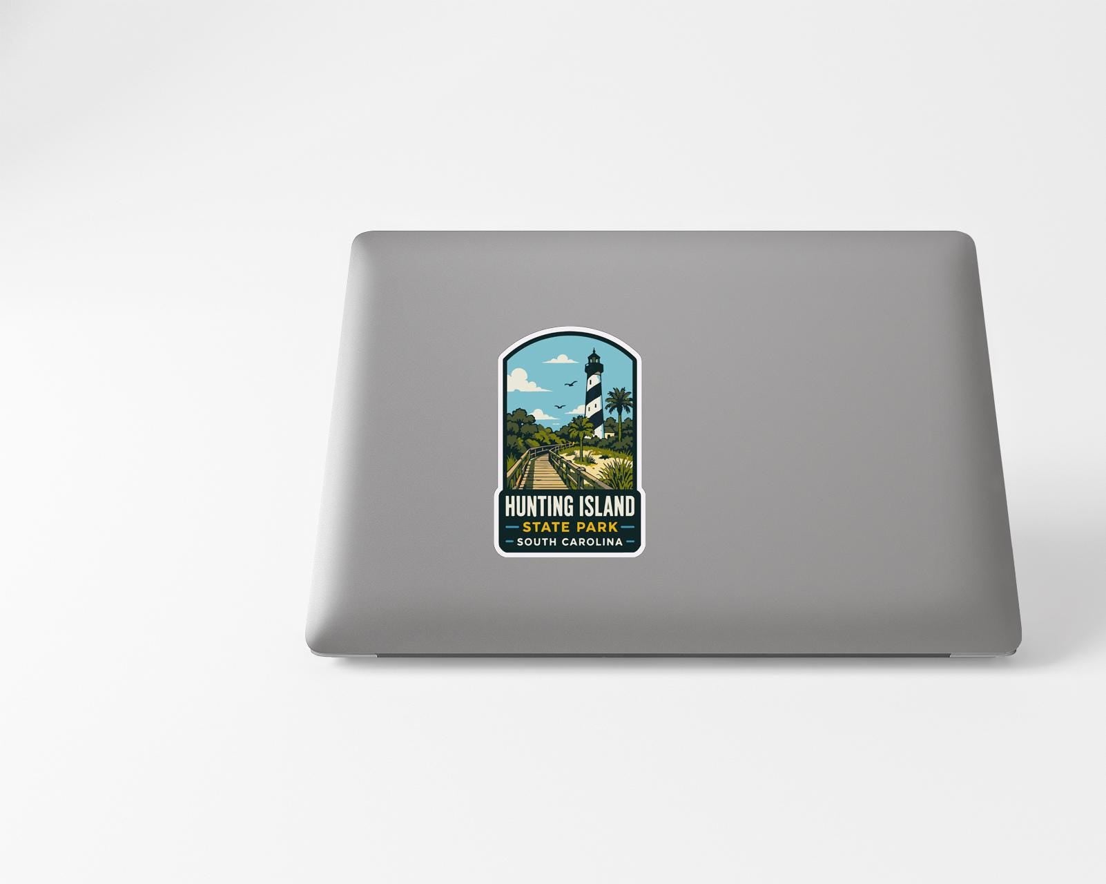 A sticker on the back of a laptop, depicting a lighthouse and a scenic landscape.