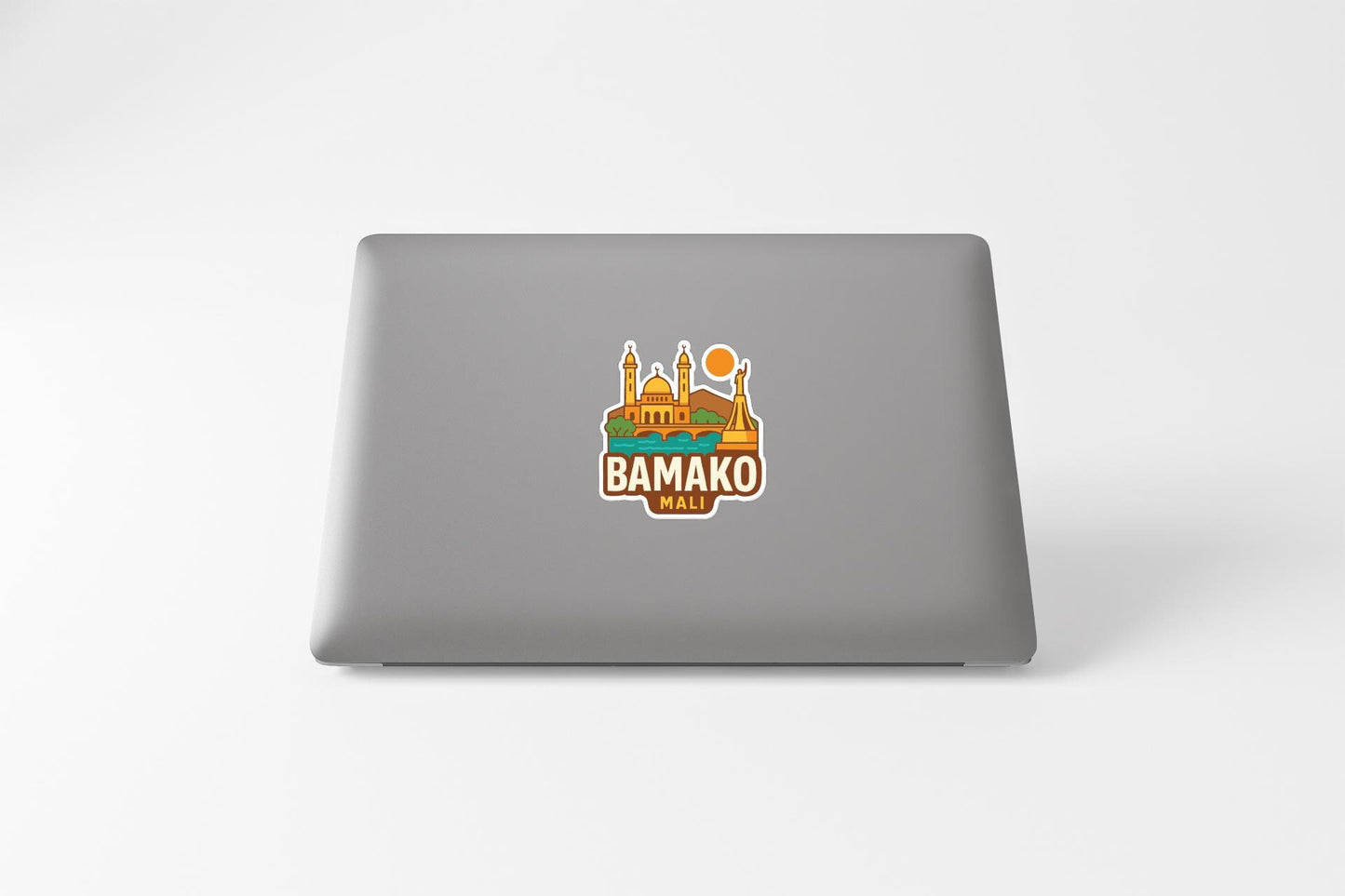 a sticker with a graphic of a building and a sun on a laptop.