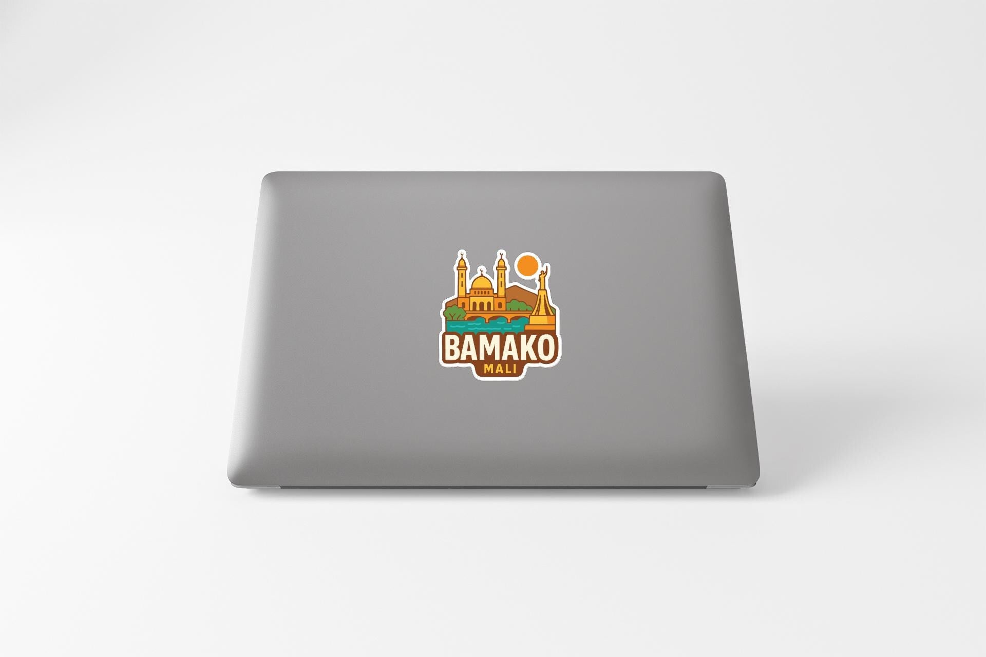 a sticker with a graphic of a building and a sun on a laptop.