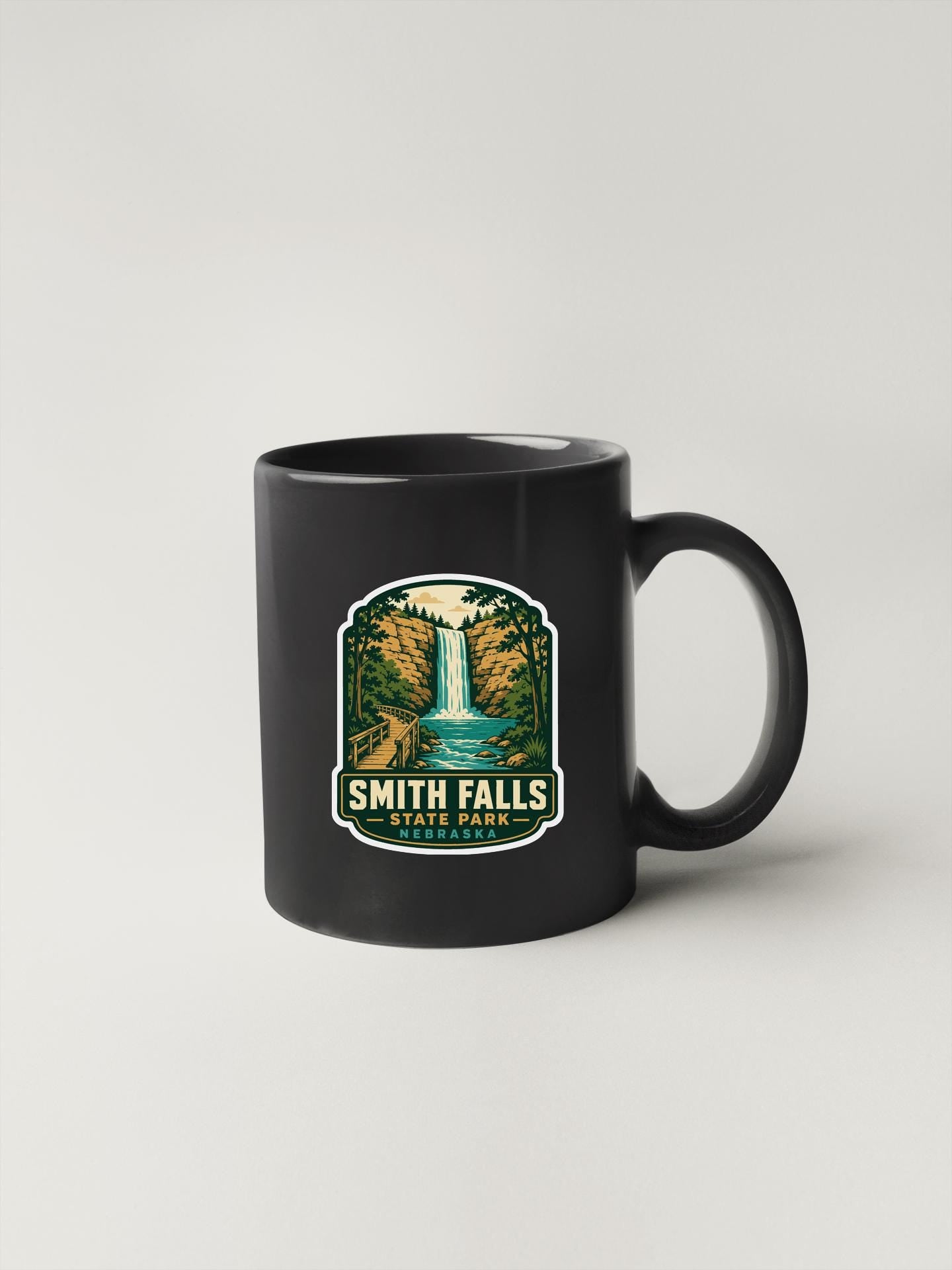A black coffee mug with a graphic design depicting Smith Falls State Park.