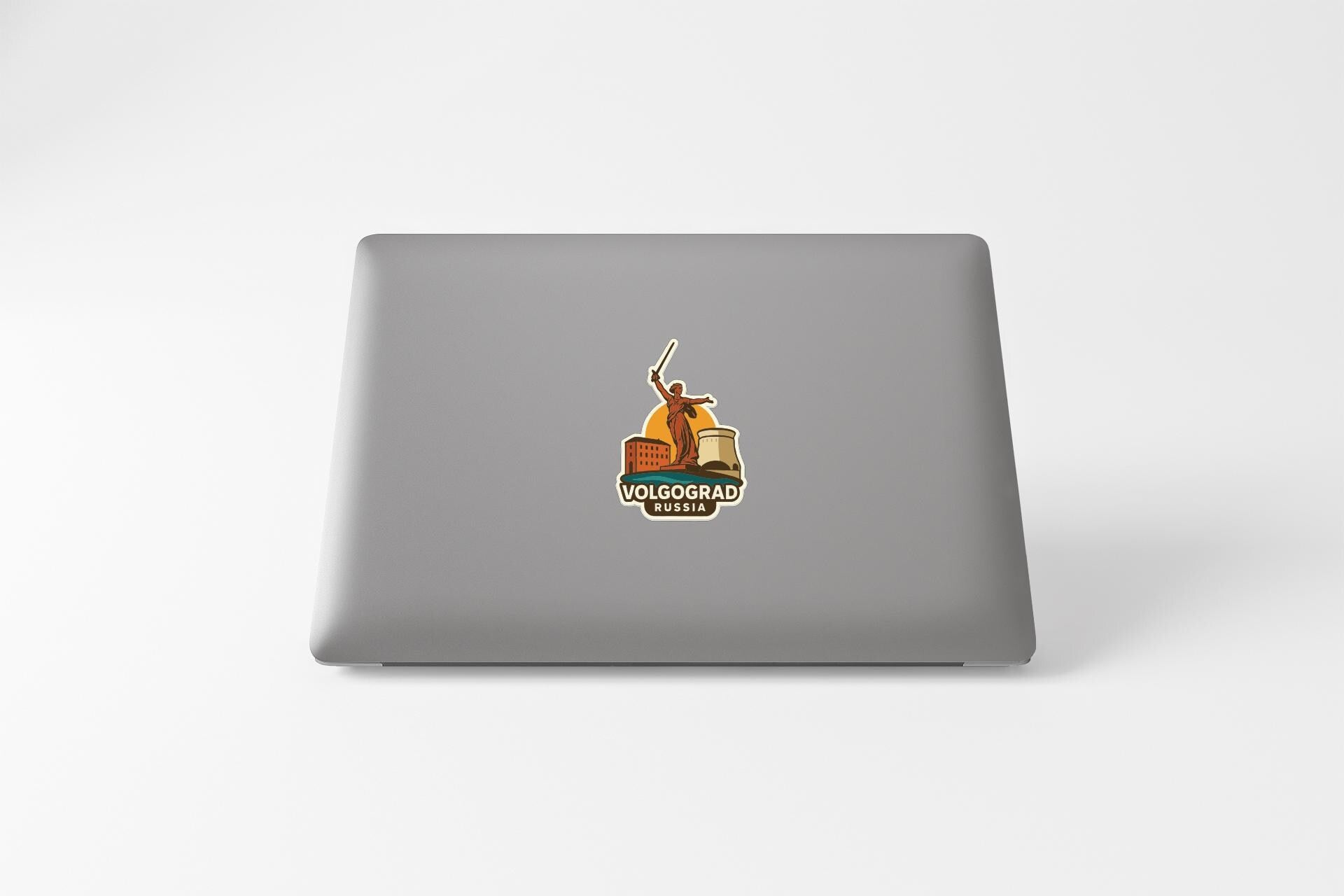 a sticker with a graphic of a person holding a flag, placed on the back of a laptop computer.
