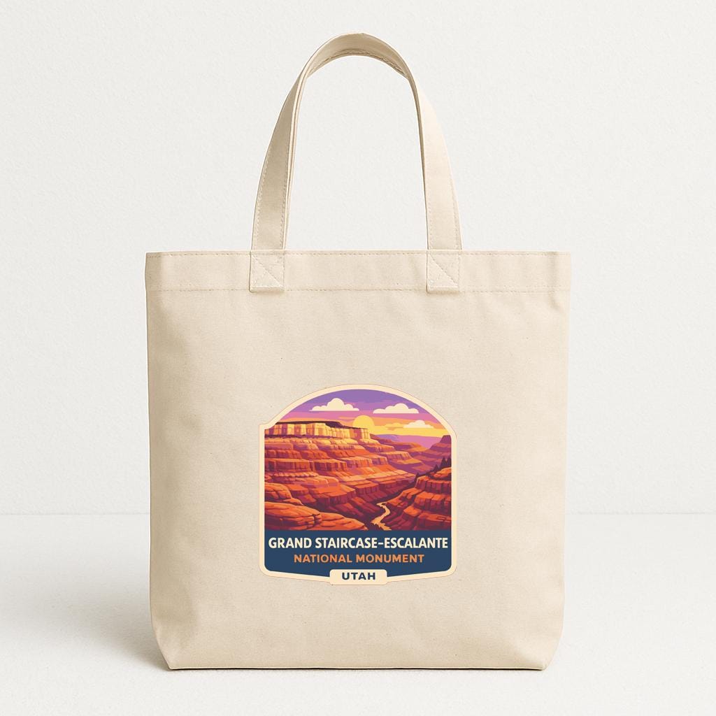 A beige tote bag with a graphic design depicting the Grand Staircase-Escalante National Monument in Utah.