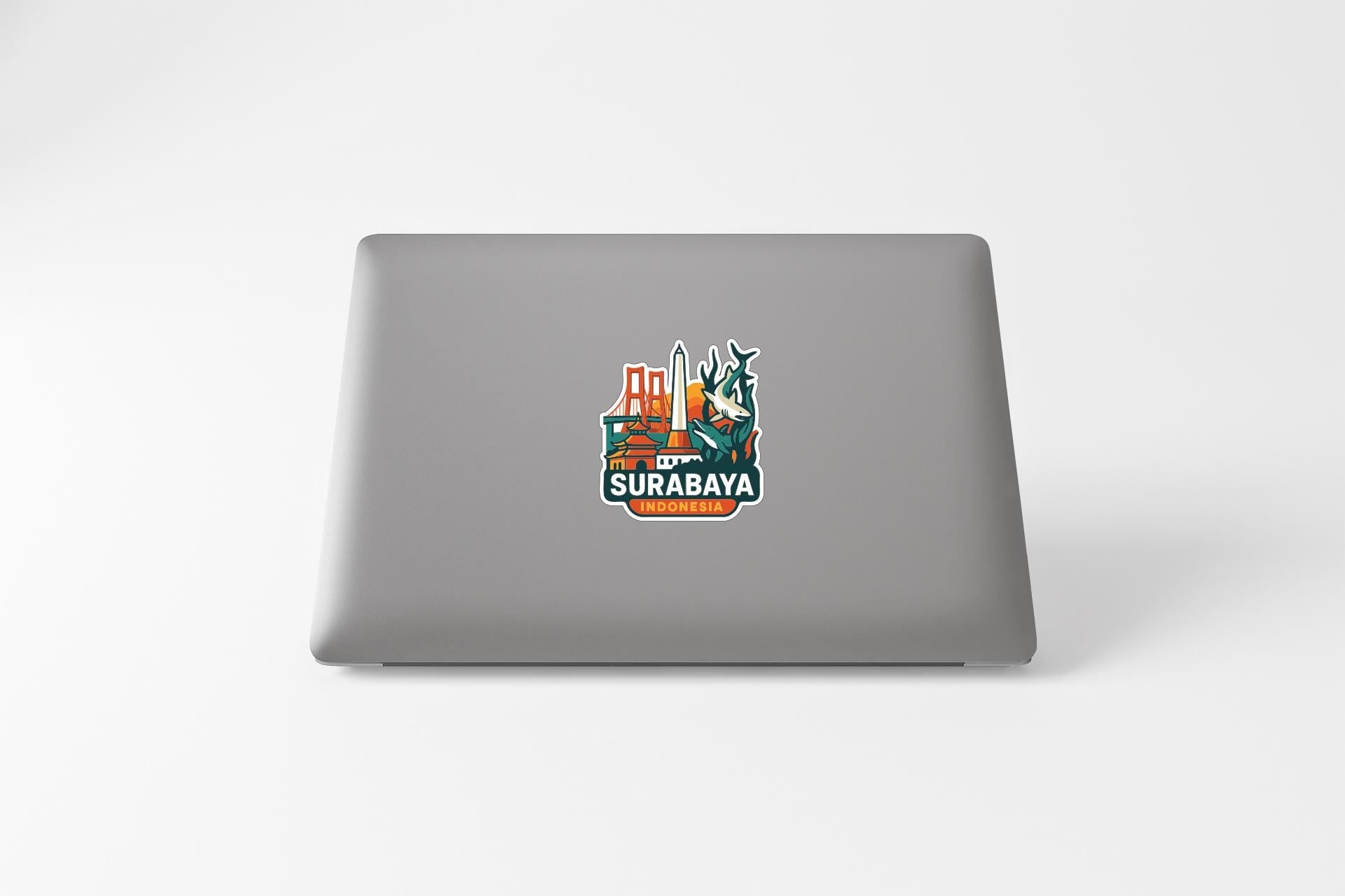 a sticker with a logo of a city skyline on the back of a laptop.