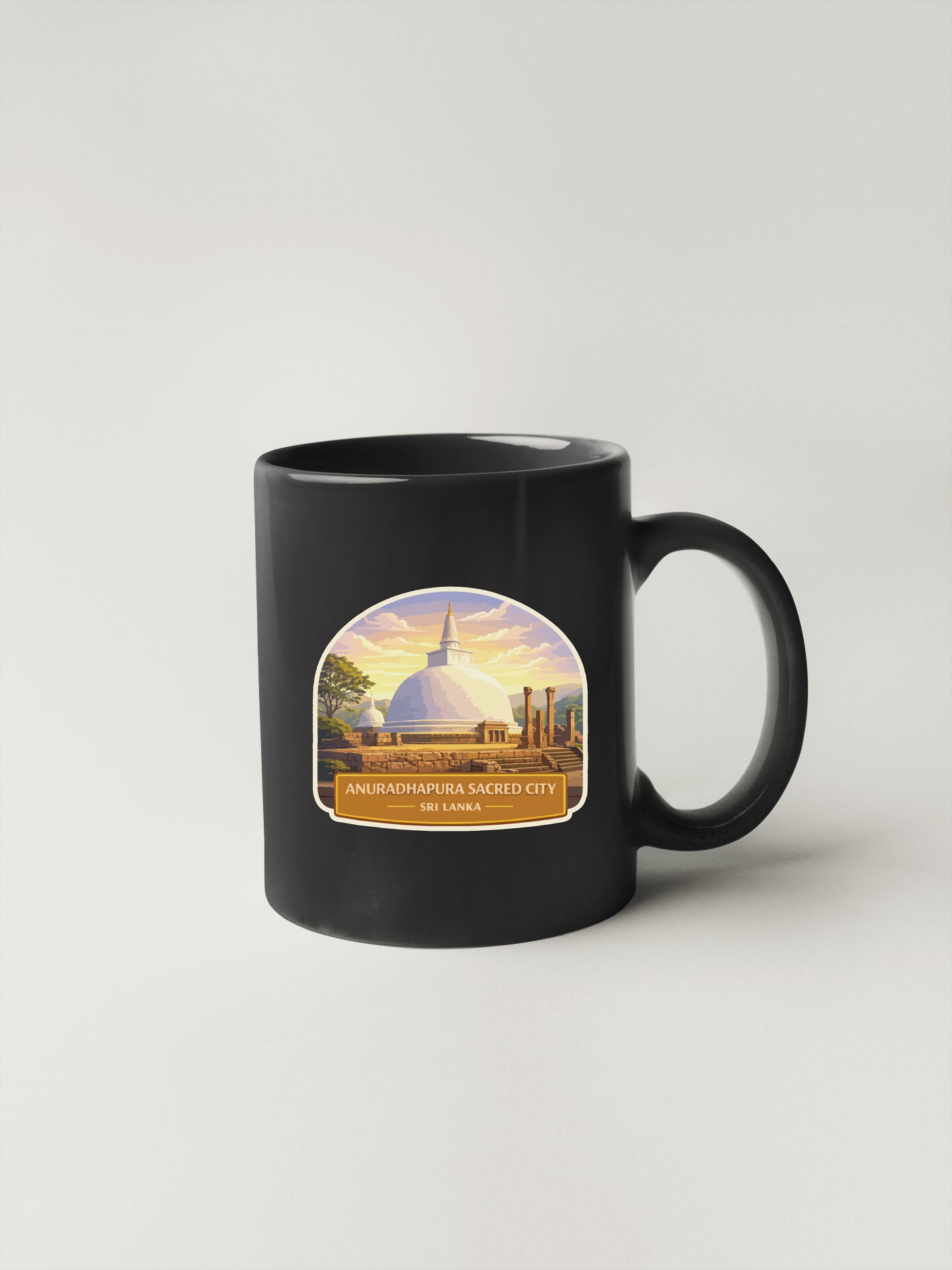 A black coffee mug with a label depicting the Anuradhapura Sacred City in Sri Lanka.