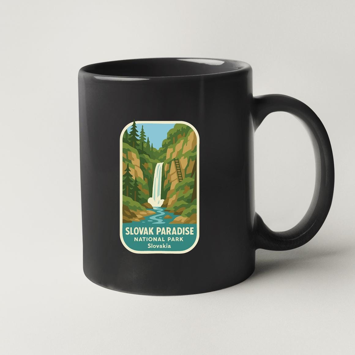 A black coffee mug with a label that features an illustration of a waterfall and forest, along with the text "SLOVAK PARADE NATIONAL PALACE Slovenia".