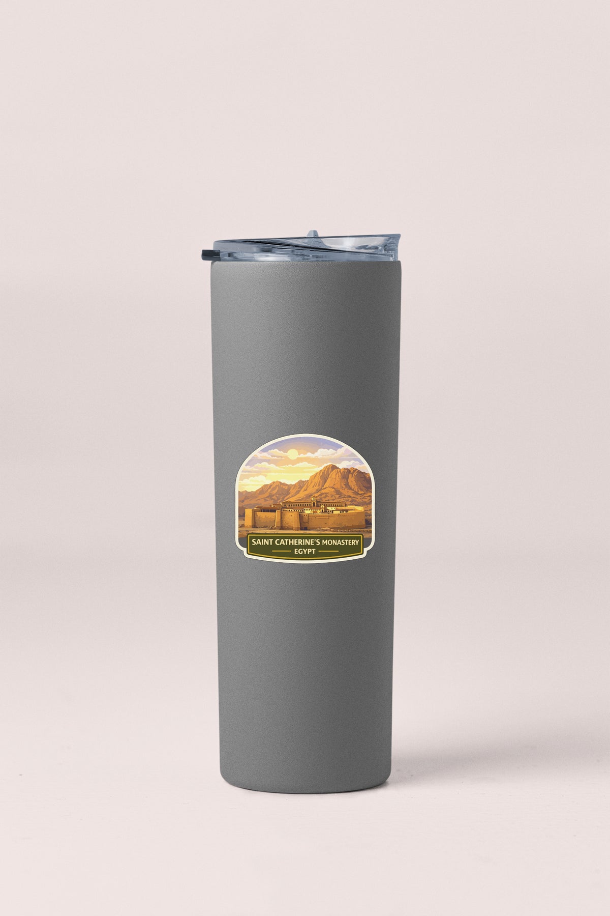 A gray insulated tumbler with a lid and a label featuring a mountain landscape.