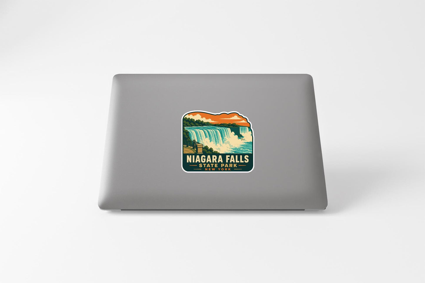 A sticker depicting Niagara Falls on the back of a laptop computer.